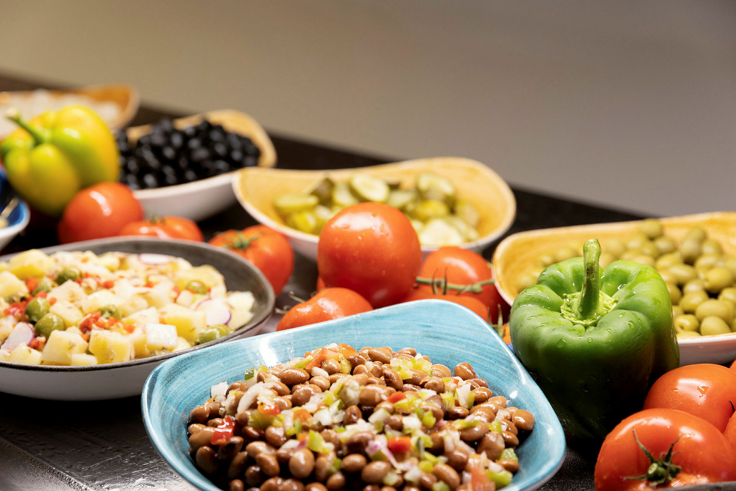 En samling av ferske grønnsaker og salat i ulike boller. (AI-generert tekst)