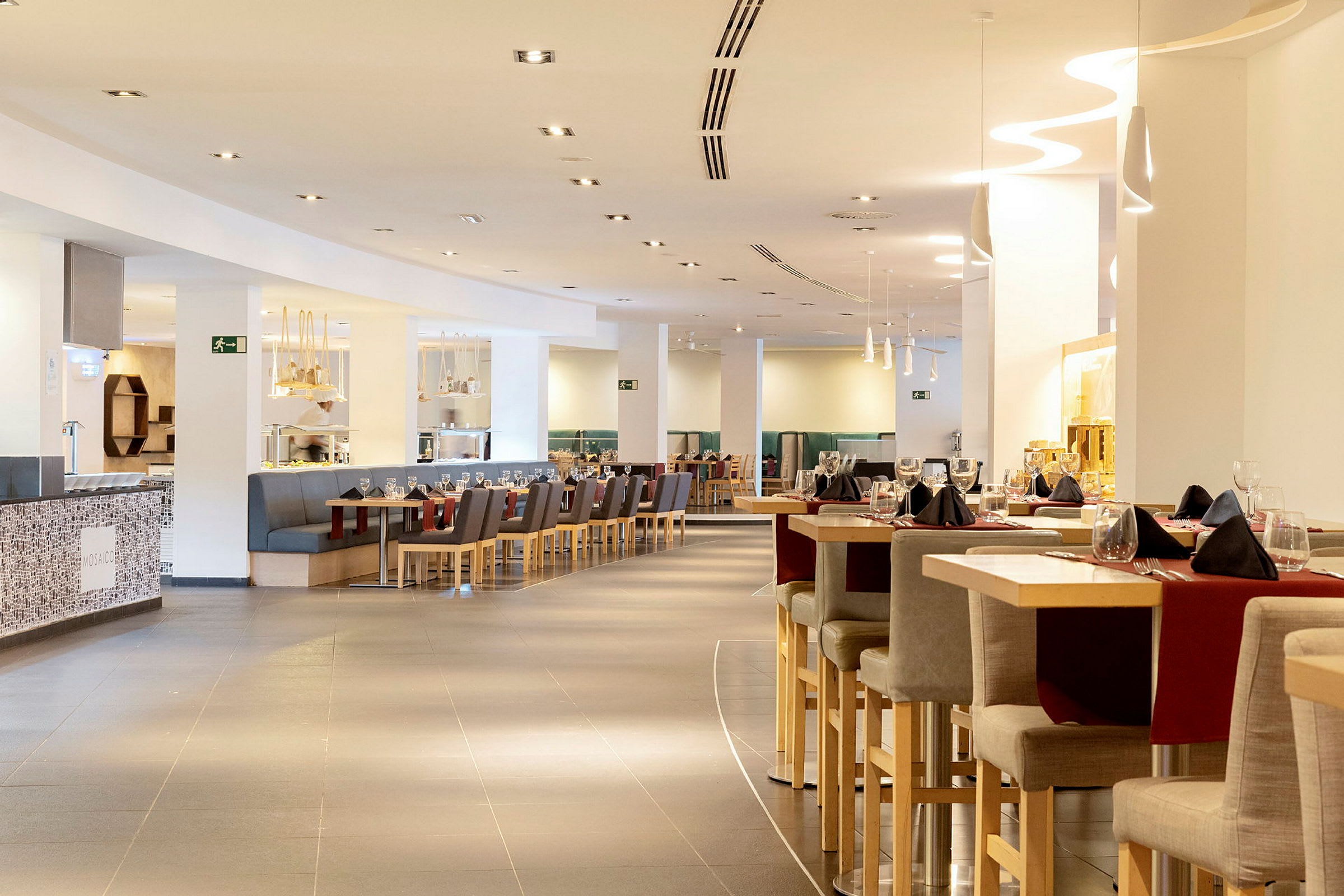 En moderne restaurant med sitteplasser og bord dekorert for middag. (AI-generert tekst)