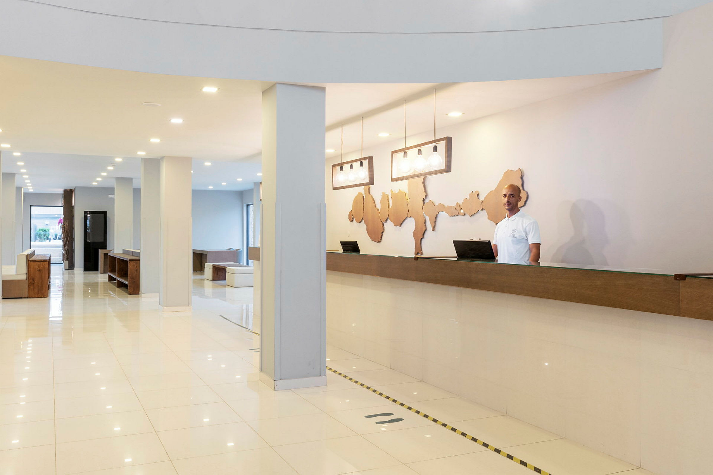 En resepsjon med skrivebord og dekorativ veggkunst i et lyst og moderne hotell. (AI-generert tekst)