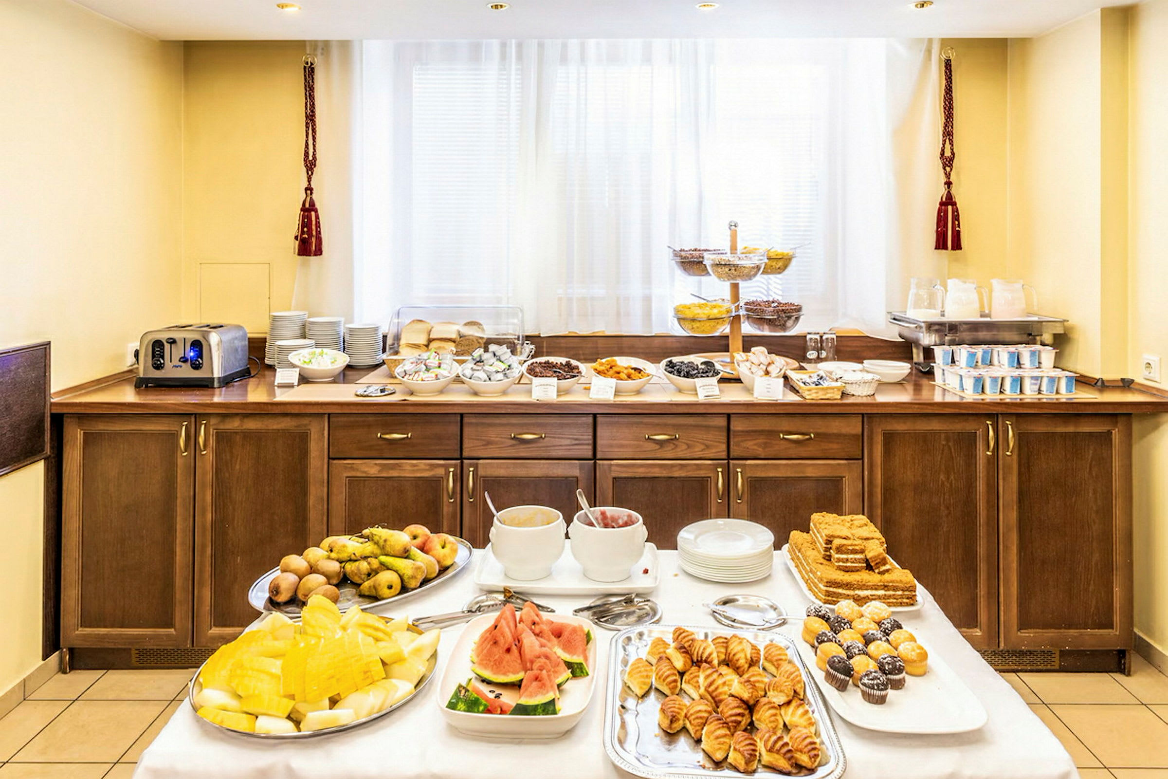 Hotellfrokostbuffé med ulike retter, inkludert frukt, bakverk og drikke. (AI-generert tekst)