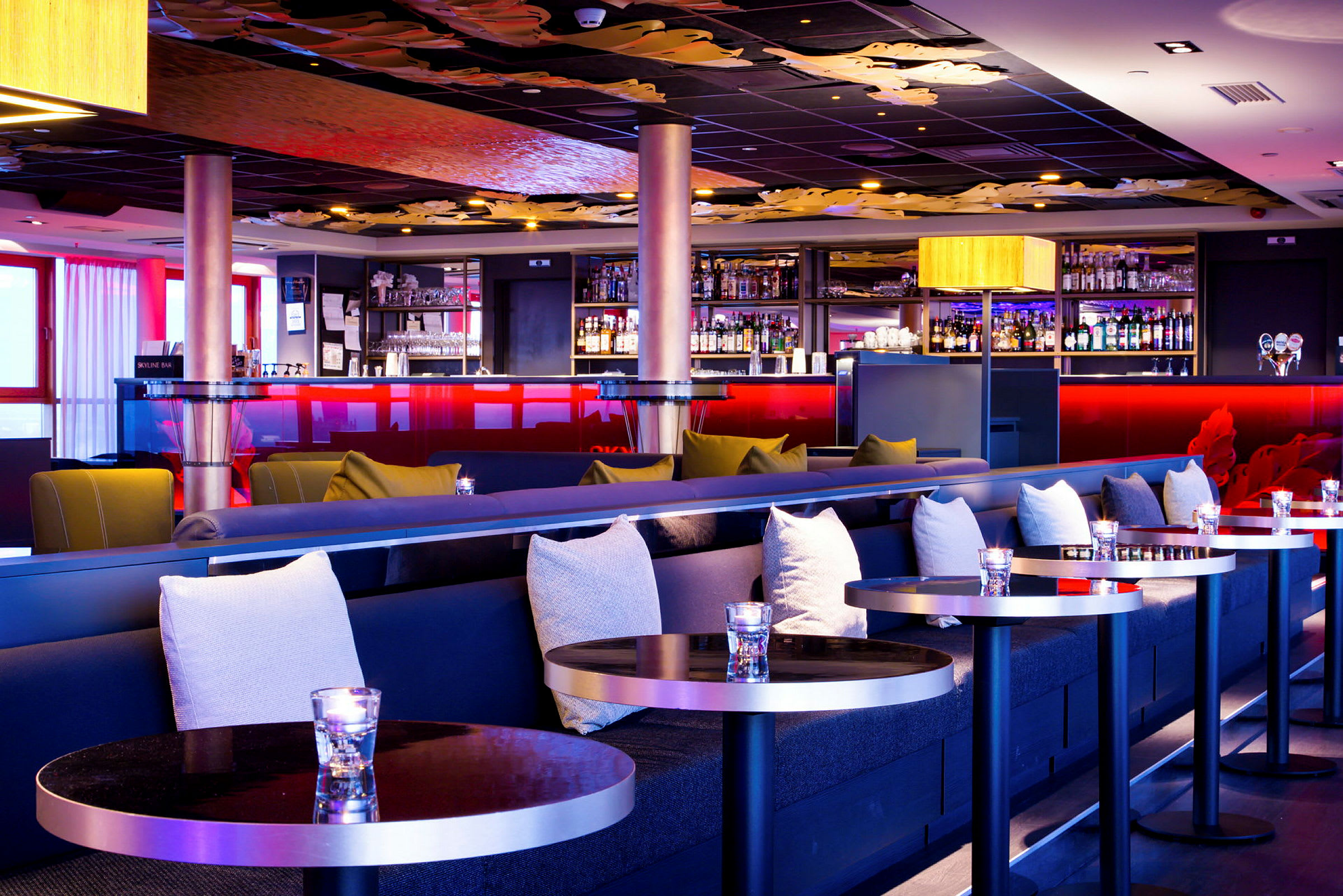 En elegant hotellbar med stilfull innredning, komfortable sofaer og et velutstyrt barskap. (AI-generert tekst)