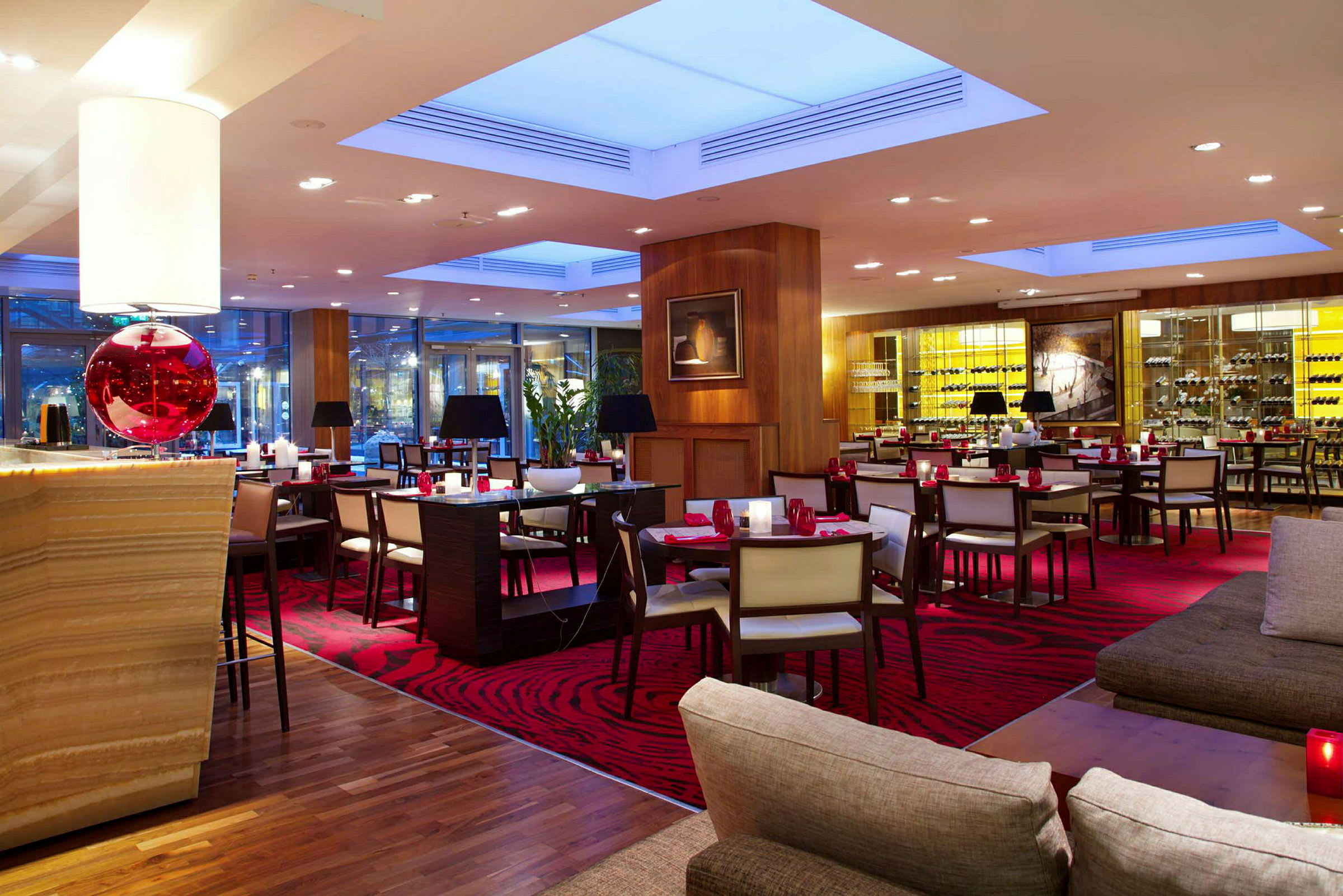 En elegant restaurant med røde tepper og moderne innredning, med bord, stoler og en avslappet atmosfære. (AI-generert tekst)