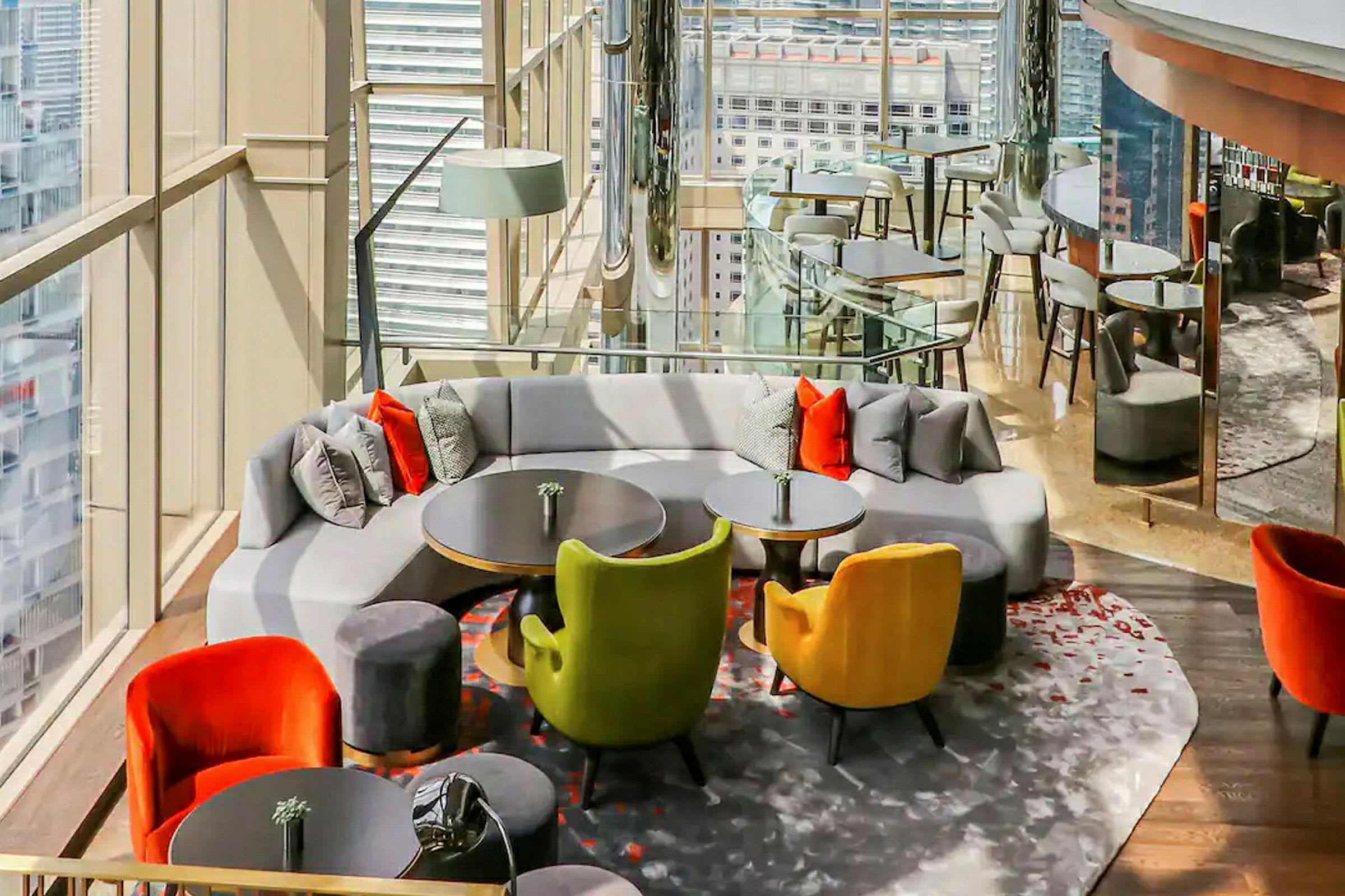 En elegant lounge med moderne møbler, puter og utsikt gjennom store glassvinduer. (AI-generert tekst)