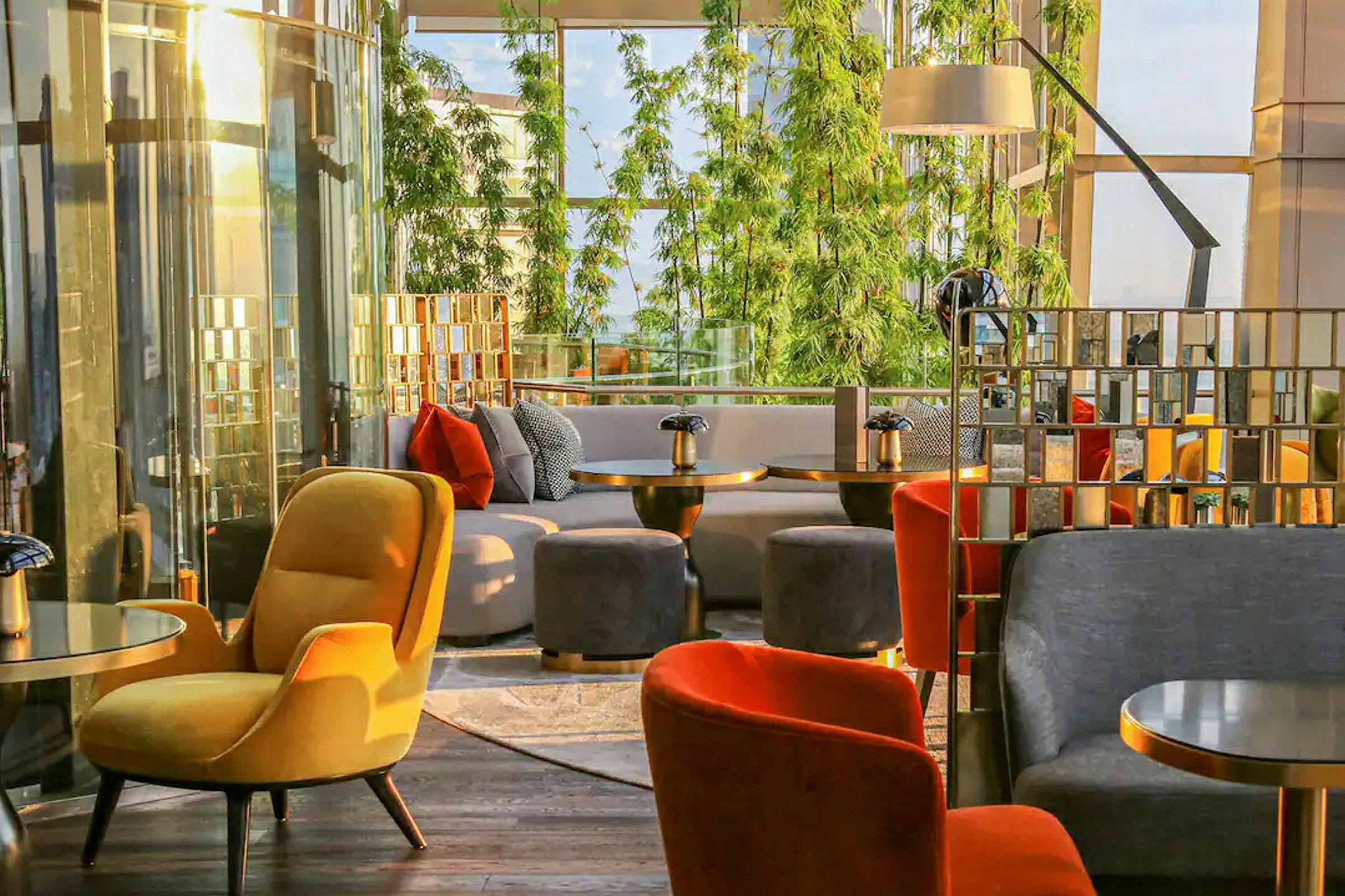Sittegruppe i moderne miljø med fargerike lenestoler og sofaer, grønn beplantning i bakgrunnen. (AI-generert tekst)