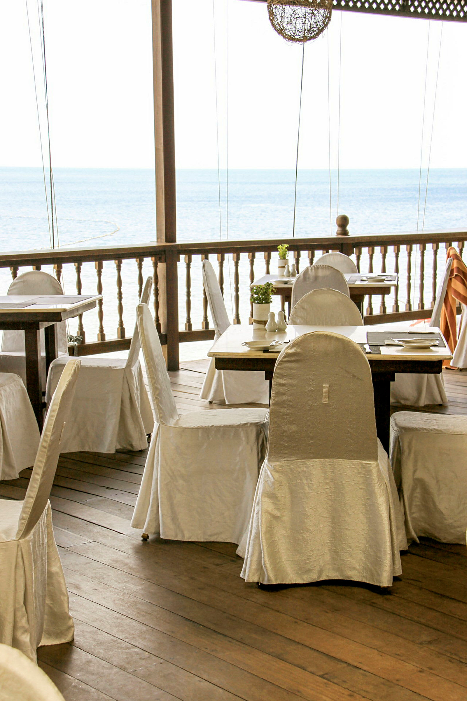 Et dekket bord på en terrasse med utsikt over havet. (AI-generert tekst)