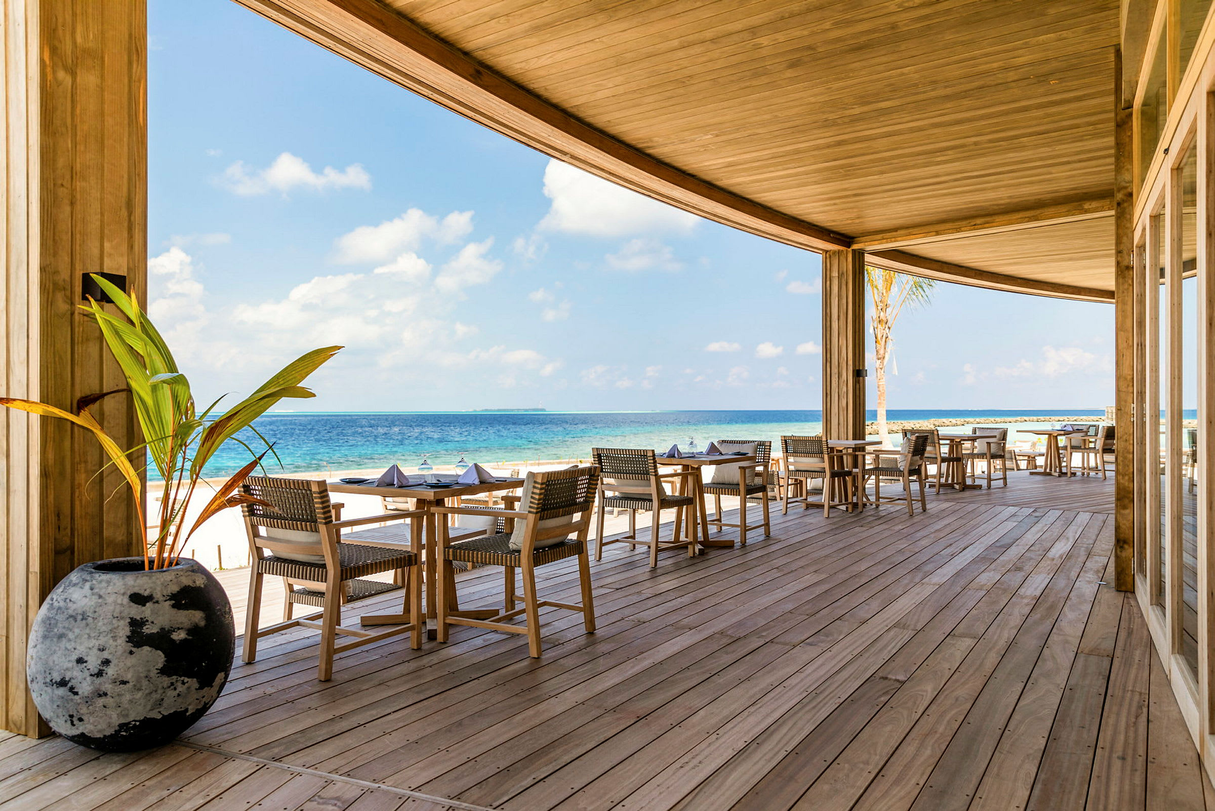 Utendørs restaurant på en veranda med utsikt over havet. (AI-generert tekst)
