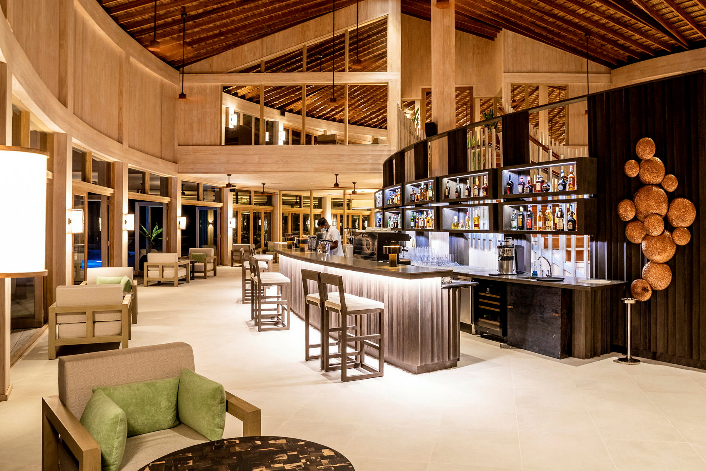 Interiør av en moderne lobby med bar, sitteplasser og dekorativ belysning. (AI-generert tekst)