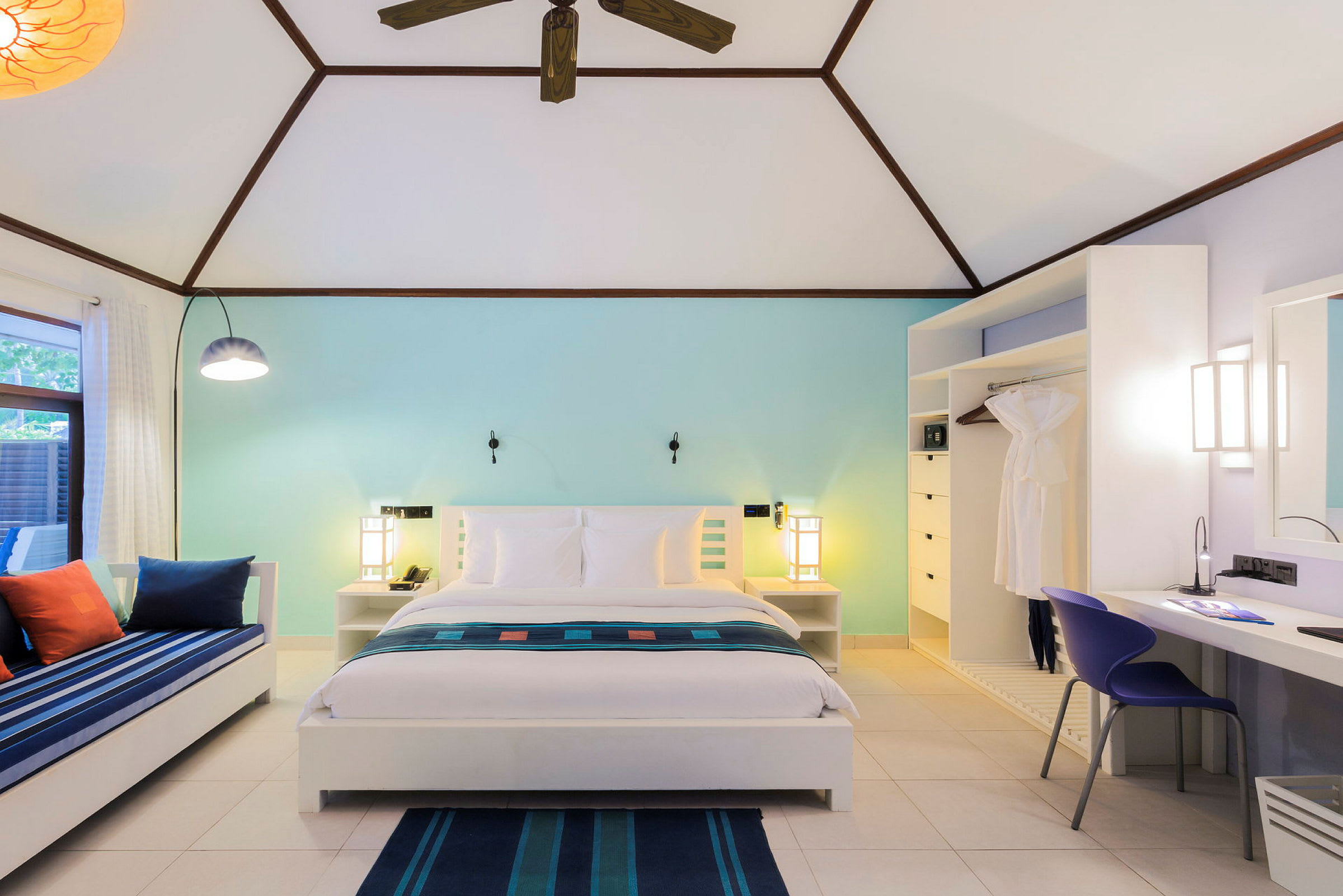 Moderne hotellrom med dobbeltseng, sitteplass og skrivebord med lys innredning. (AI-generert tekst)