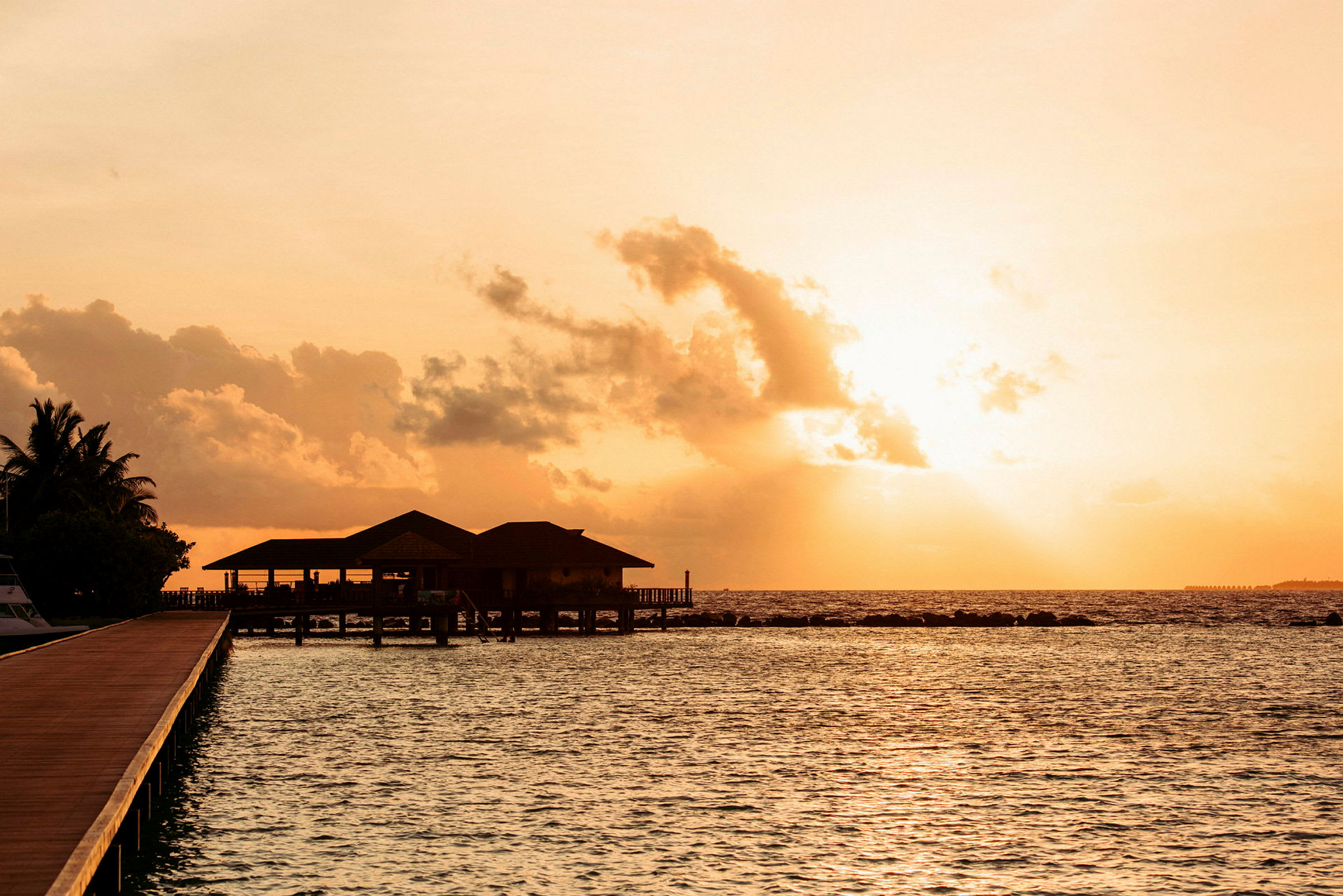 Solnedgang over en overwater-villa ved havet. (AI-generert tekst)