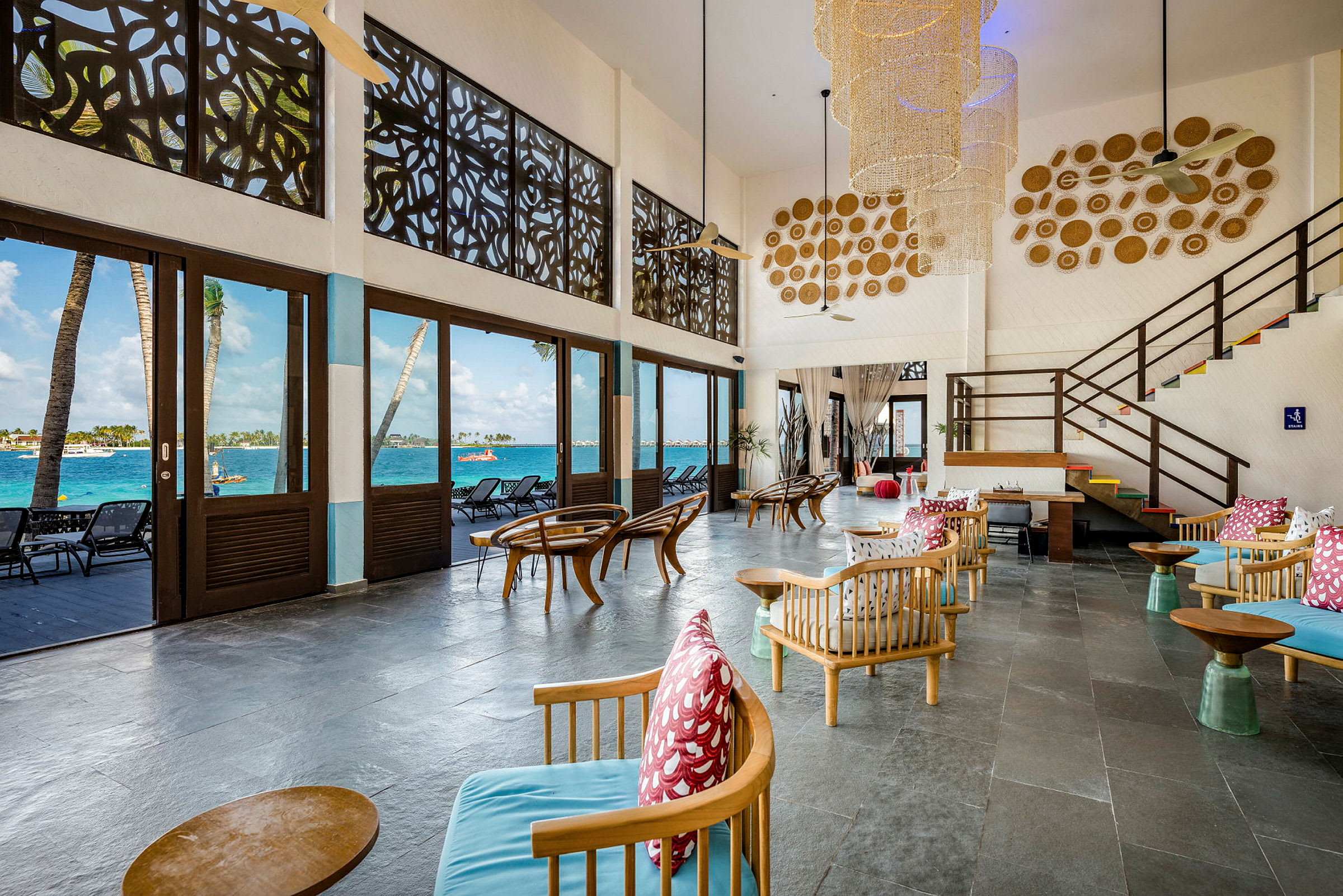 Interiør av en lounge med sittegrupper og utsikt mot havet. (AI-generert tekst)