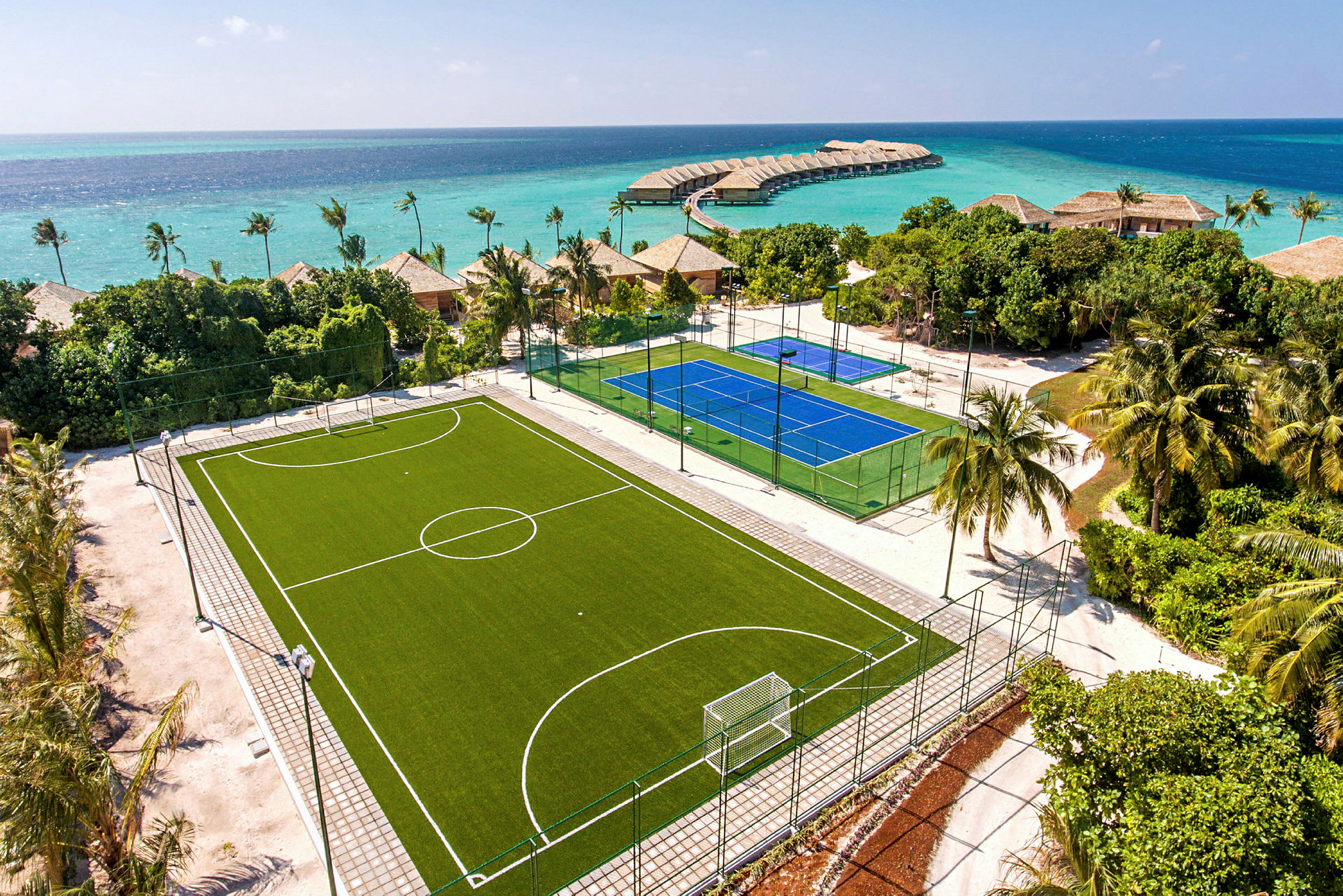 En fotballbane og en tennisbane ved stranden. (AI-generert tekst)
