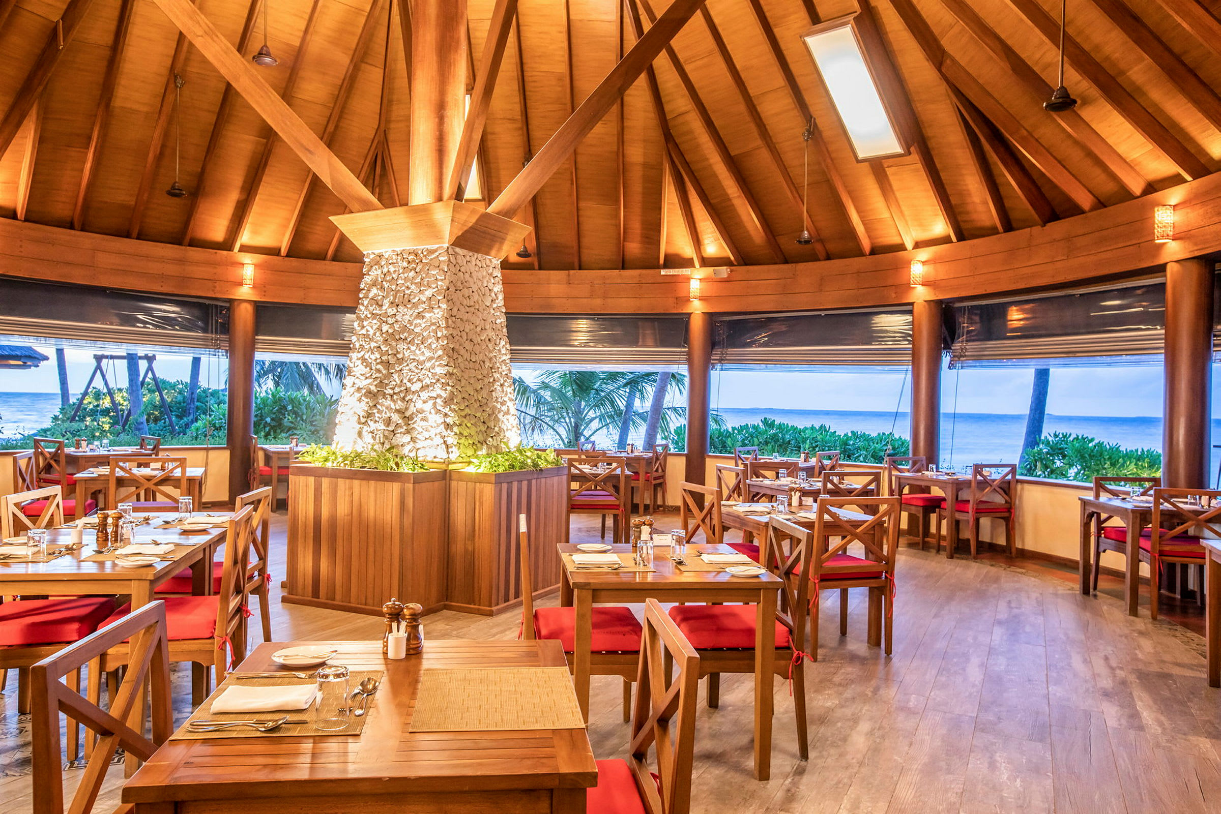 Restaurant med treinteriør og utsikt mot havet. (AI-generert tekst)