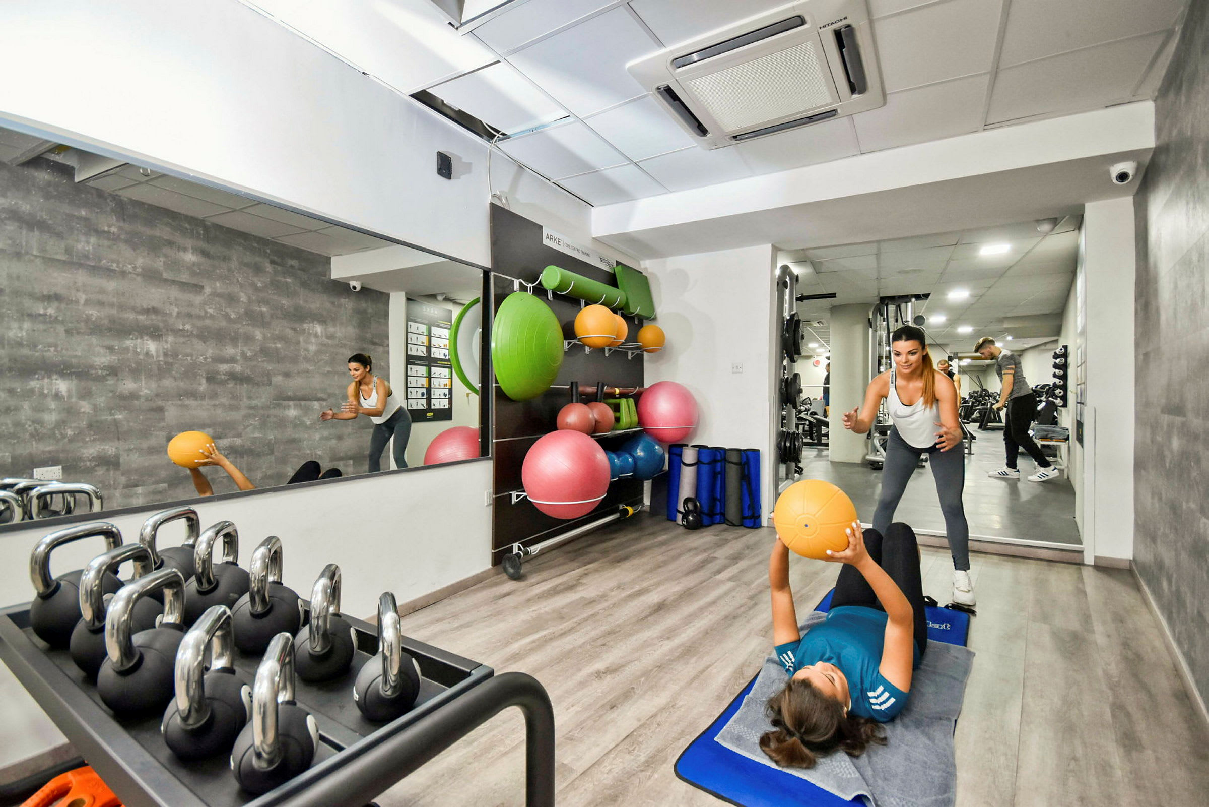 Et innendørsgym med treningsballer, manualer og speil. (AI-generert tekst)