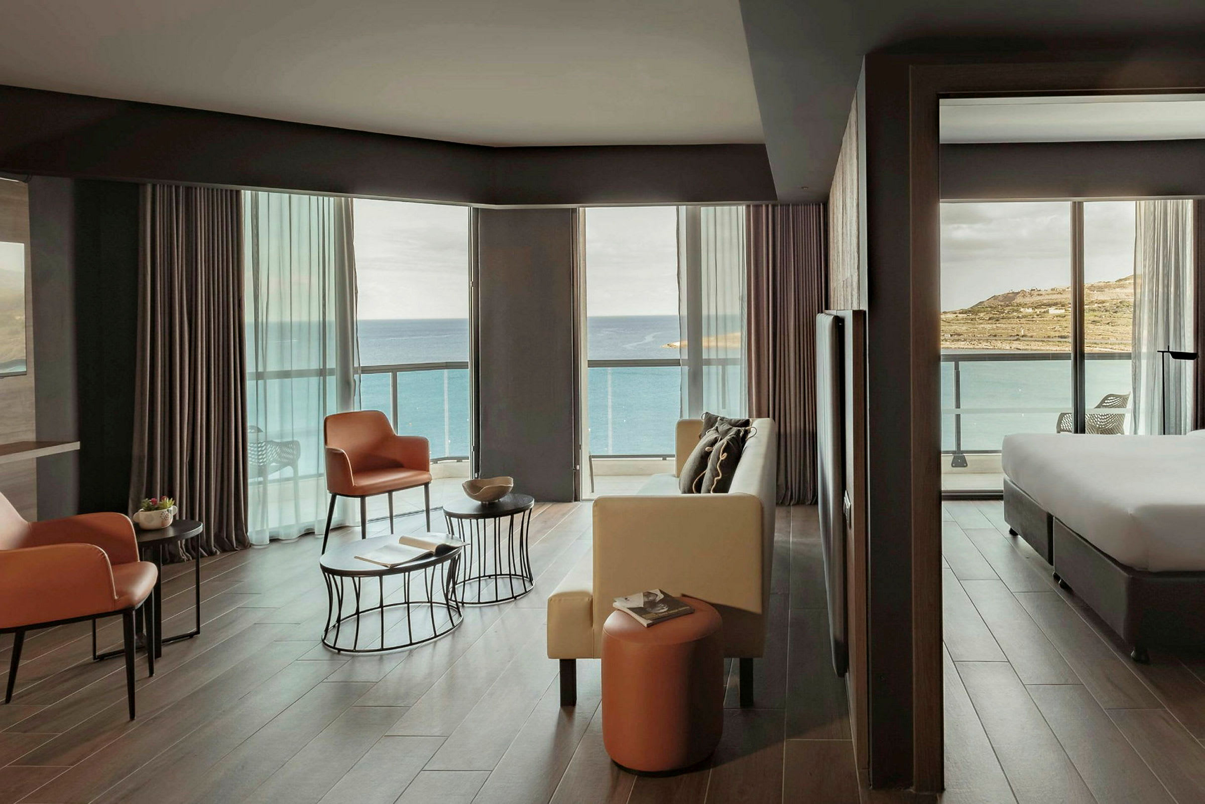Et hotellrom med moderne innredning og store vinduer med utsikt over havet. (AI-generert tekst)
