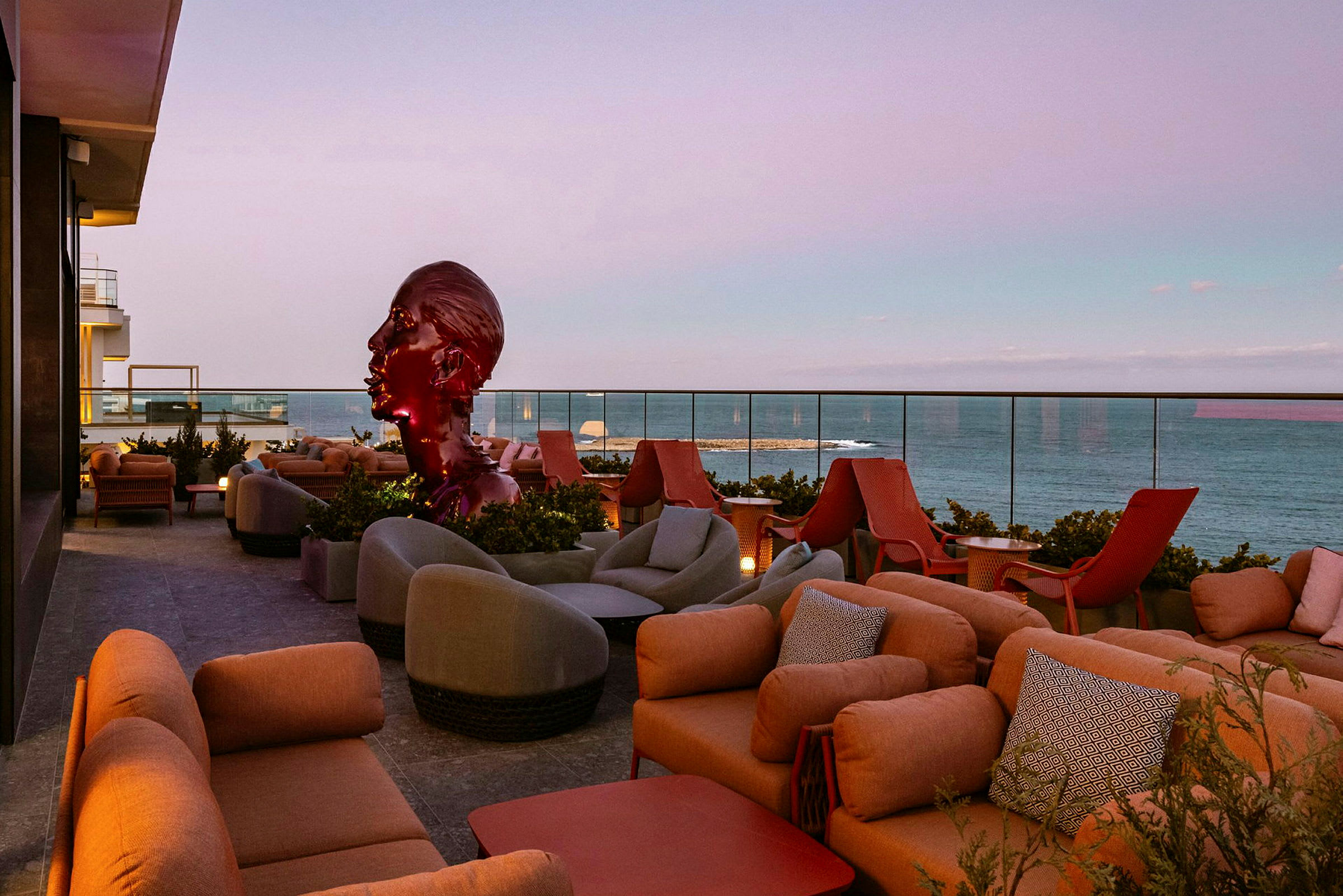 En terrasse med sitteplasser og utsikt over havet. (AI-generert tekst)