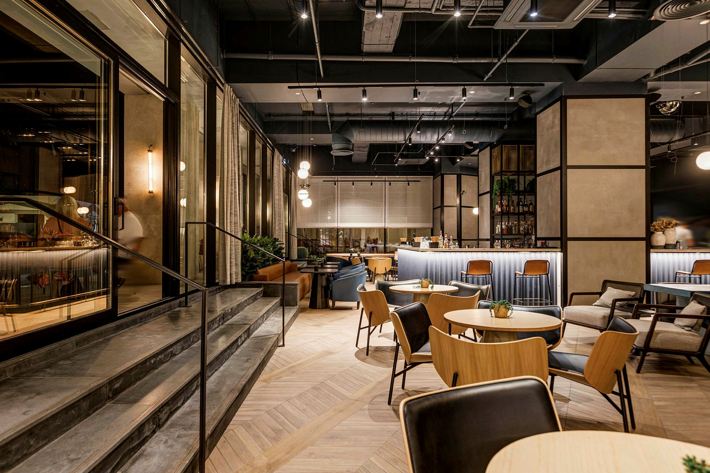 Interiør av en moderne restaurant med bord, stoler og en bardisk. (AI-generert tekst)