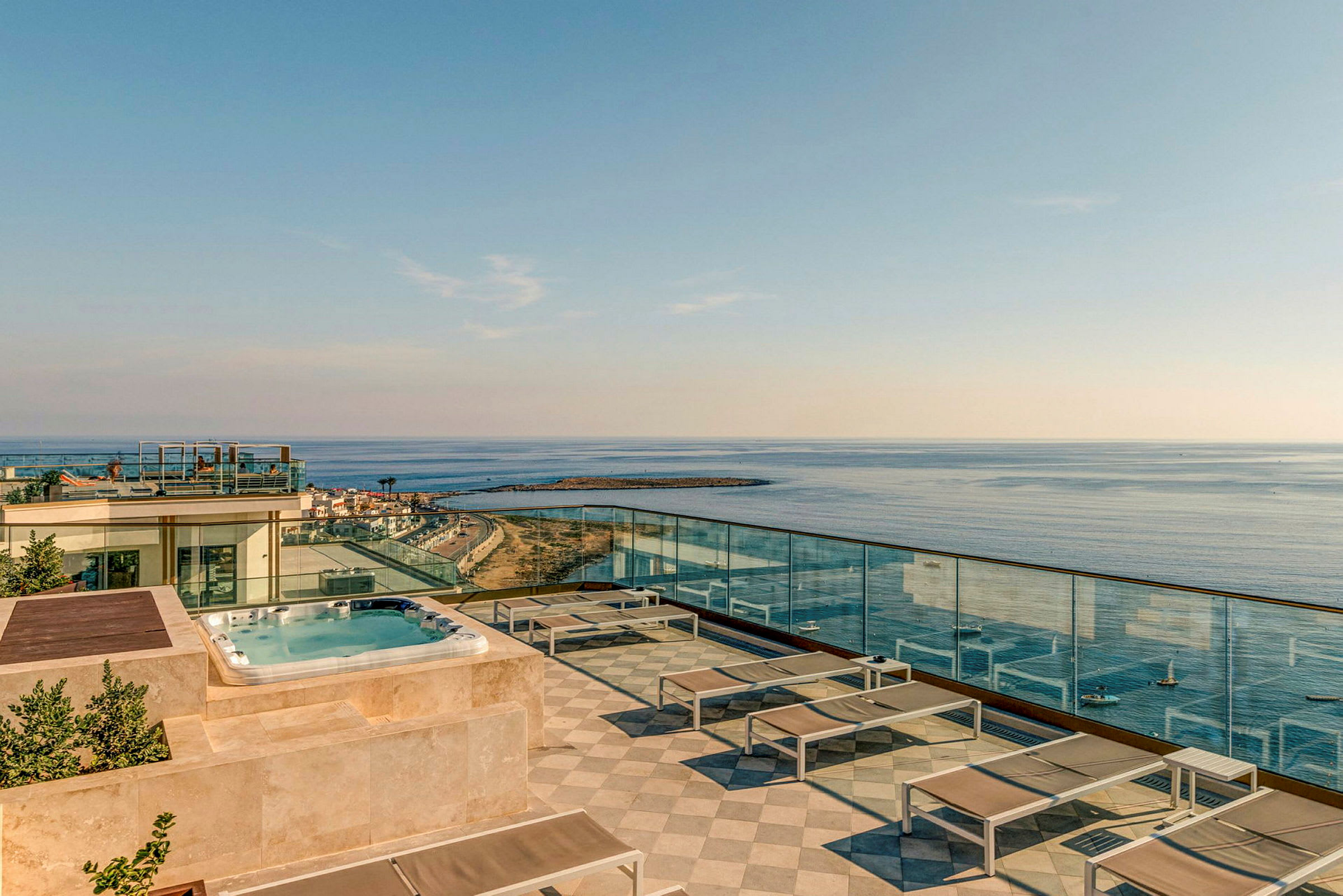 Takterrasse med basseng, solsenger og utsikt over havet. (AI-generert tekst)