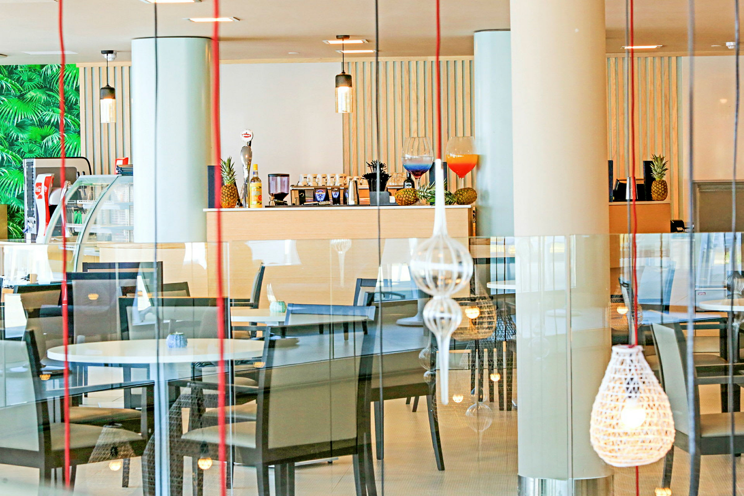 Inne i en restaurant med bord, stoler og dekorative lamper. (AI-generert tekst)