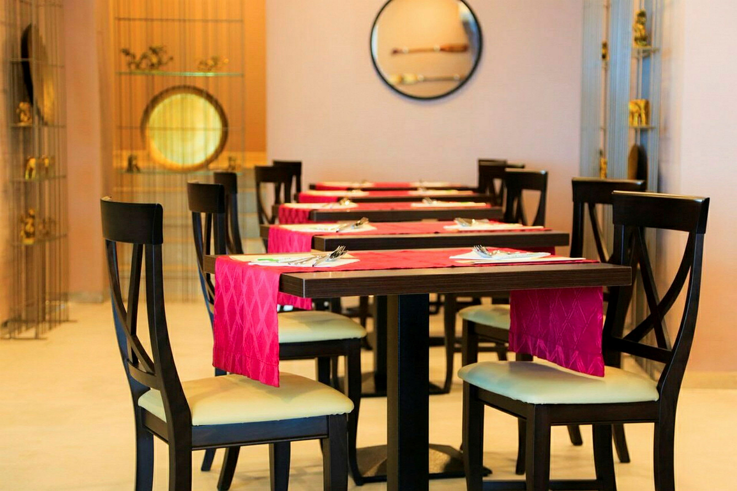 Restaurantbord og stoler med rødt serviett. (AI-generert tekst)