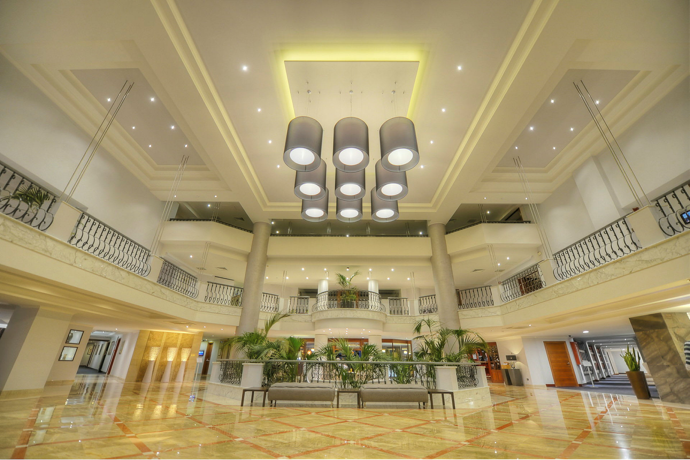 Bilde av en elegant hotellobby med en lysekrone i midten og moderne interiør. (AI-generert tekst)