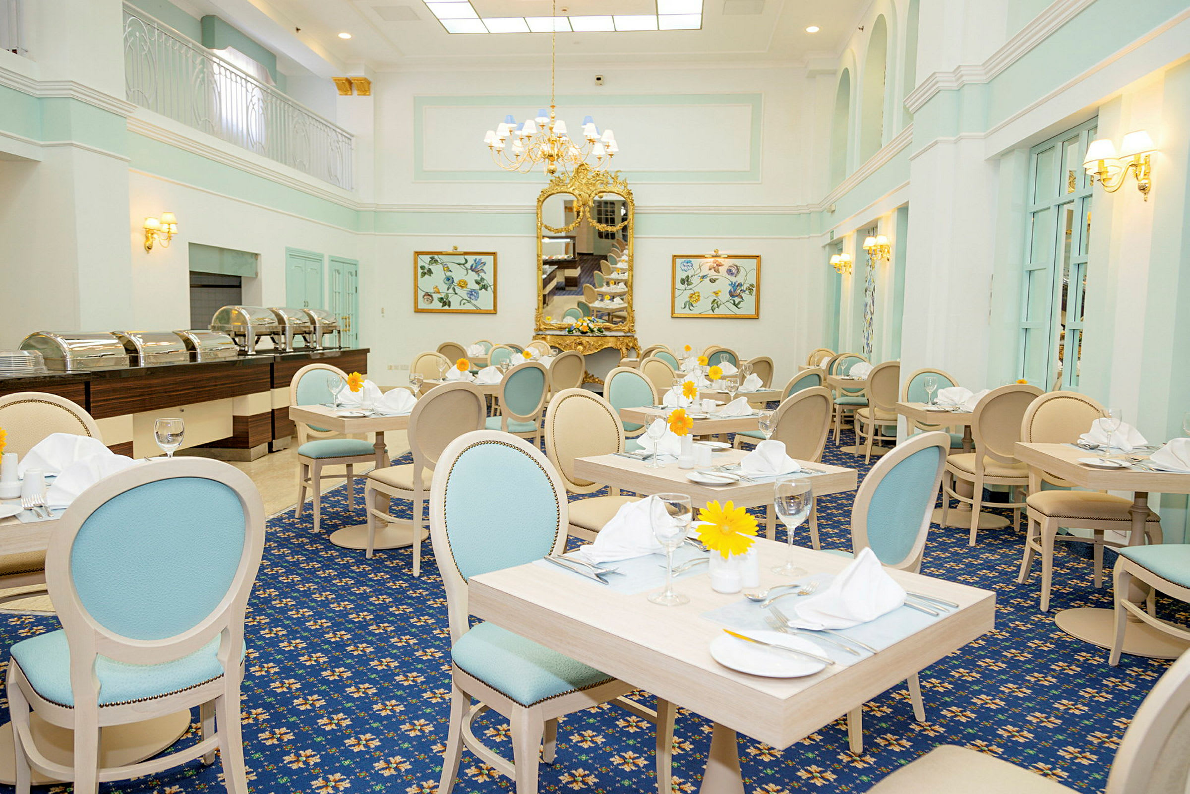 En elegant restaurant med lyse pastellfargede møbler, dekorerte bord og et stort speil i gull som pryder veggen. (AI-generert tekst)
