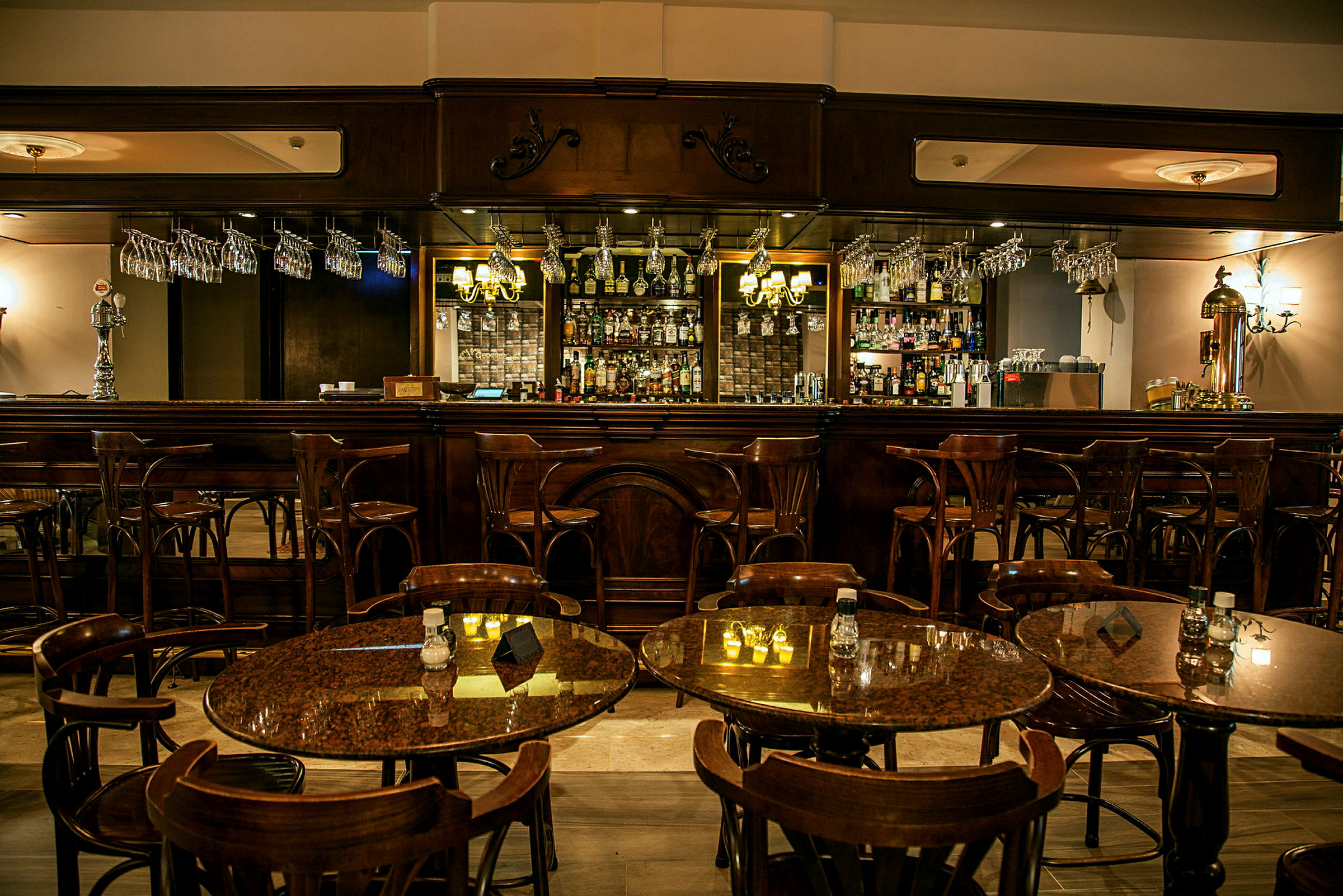 En elegant bar med treinnredning og bordgrupper med stoler i forgrunnen. (AI-generert tekst)
