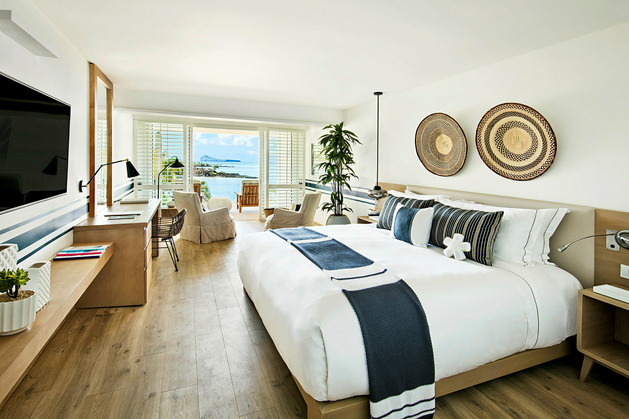 Et lyst og moderne hotellrom med utsikt over havet. (AI-generert tekst)