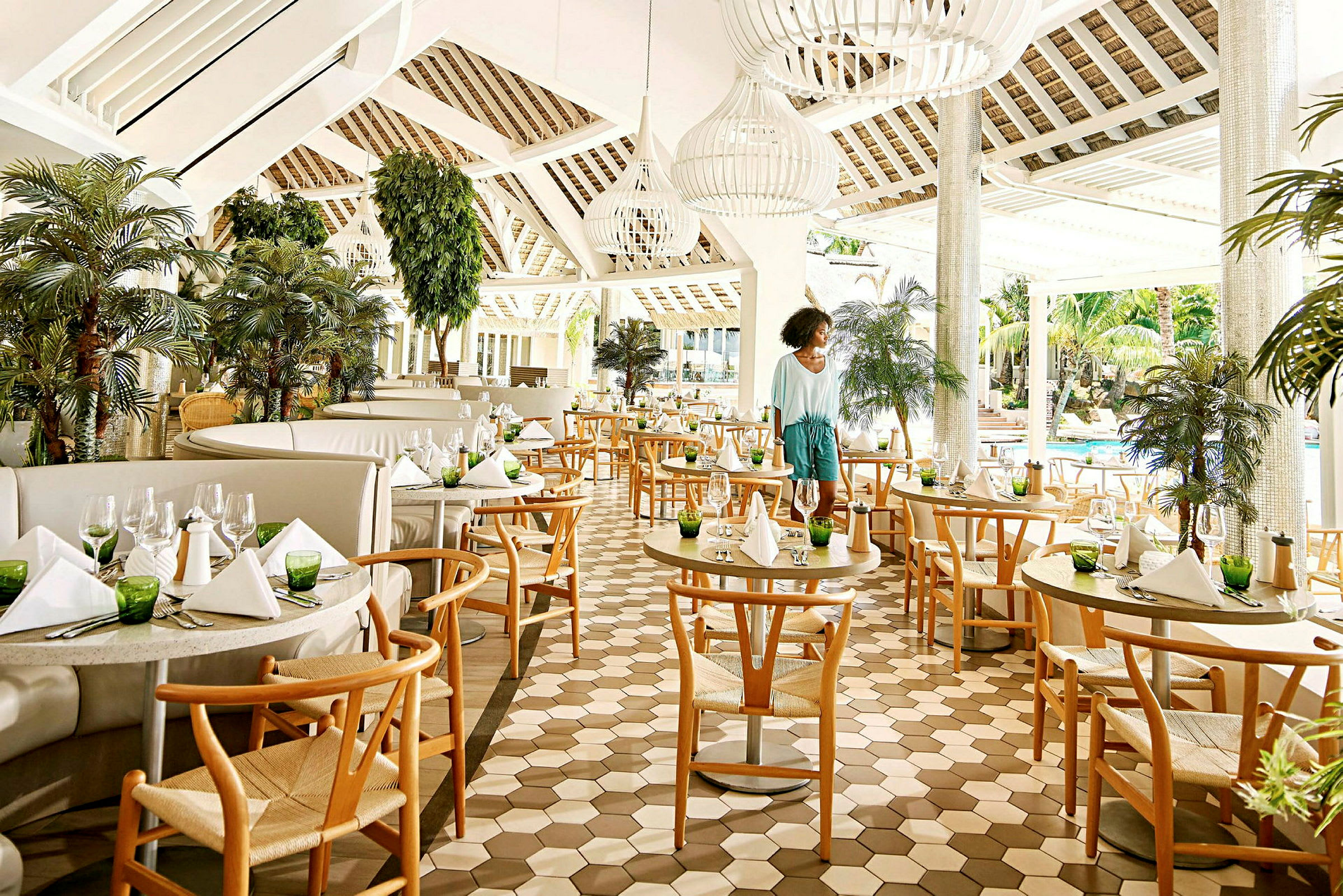 En elegant restaurant med trestoler, dekorerte bord og grønnplanter. (AI-generert tekst)