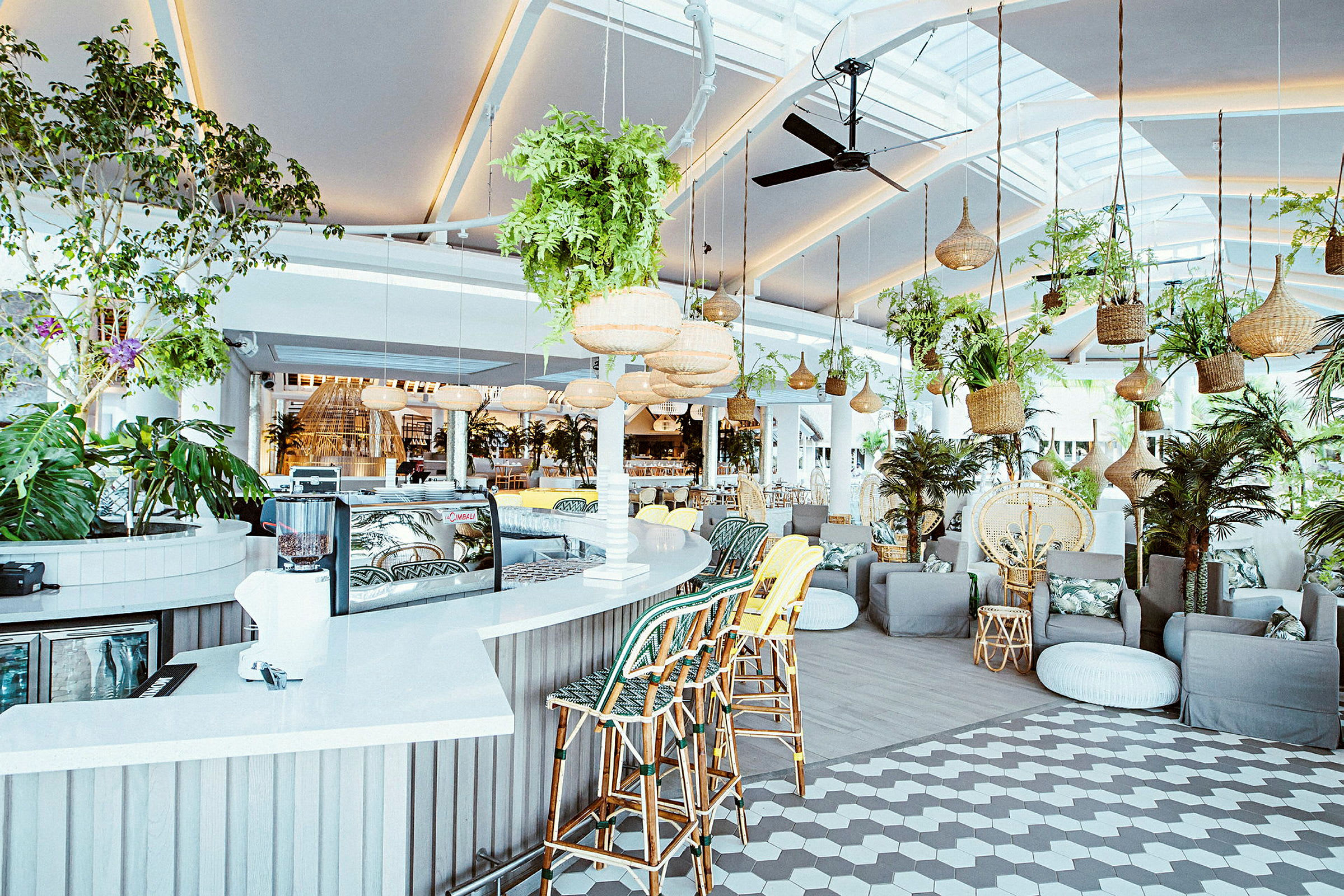 En luftig restaurant med moderne møbler og grønne planter. (AI-generert tekst)