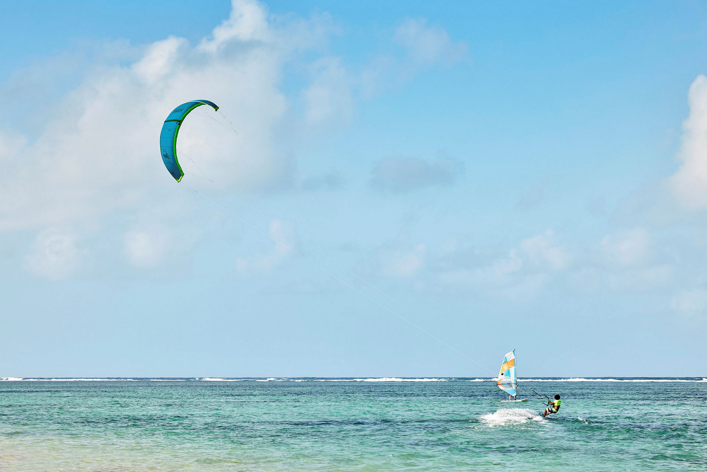 Person som kitesurfer på havet under en blå himmel. (AI-generert tekst)