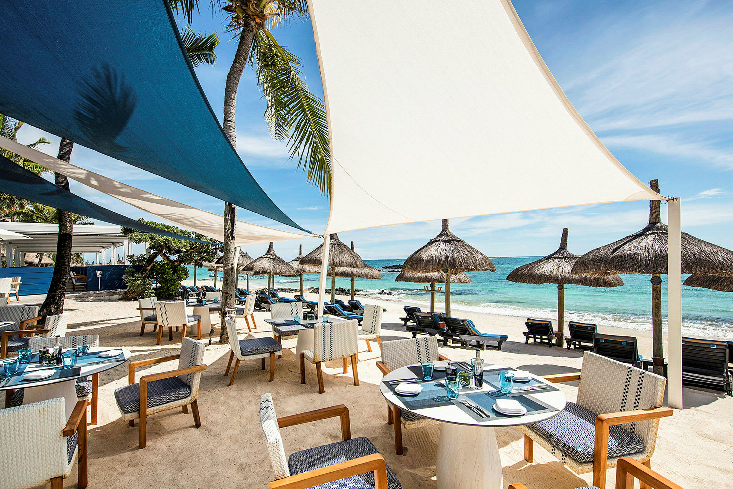 Restaurant ved stranden med sitteplasser og parasoller. (AI-generert tekst)
