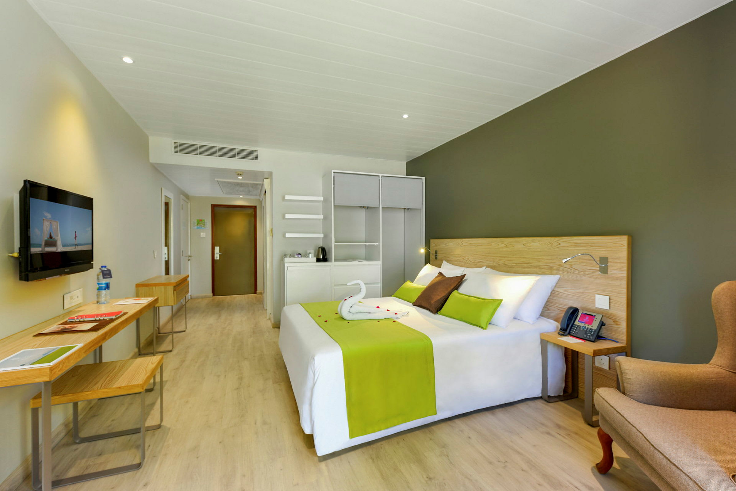 Hotellrom med seng, sittegruppe og skrivebord. (AI-generert tekst)