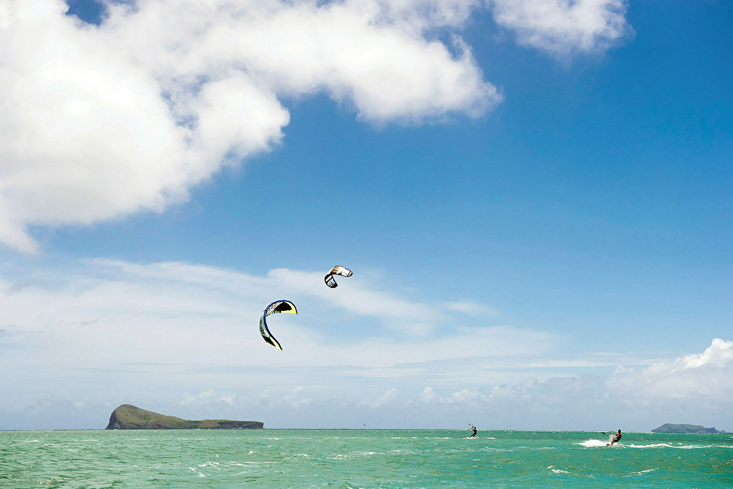 Kitesurfere på havet under klar himmel. (AI-generert tekst)