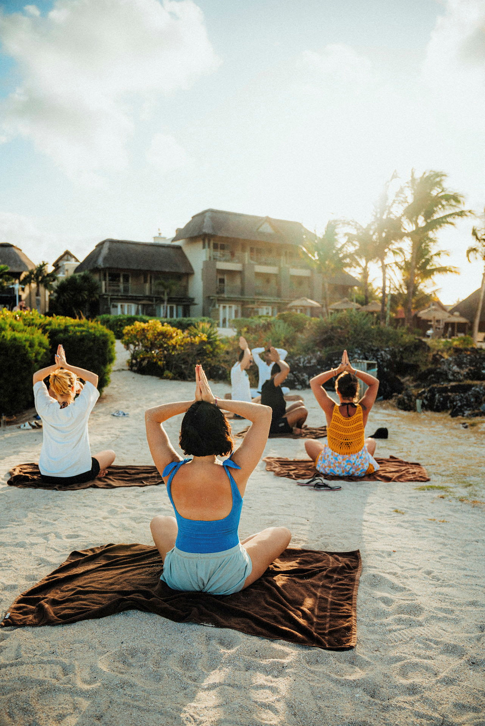Personer gjør yoga på en sandstrand. (AI-generert tekst)