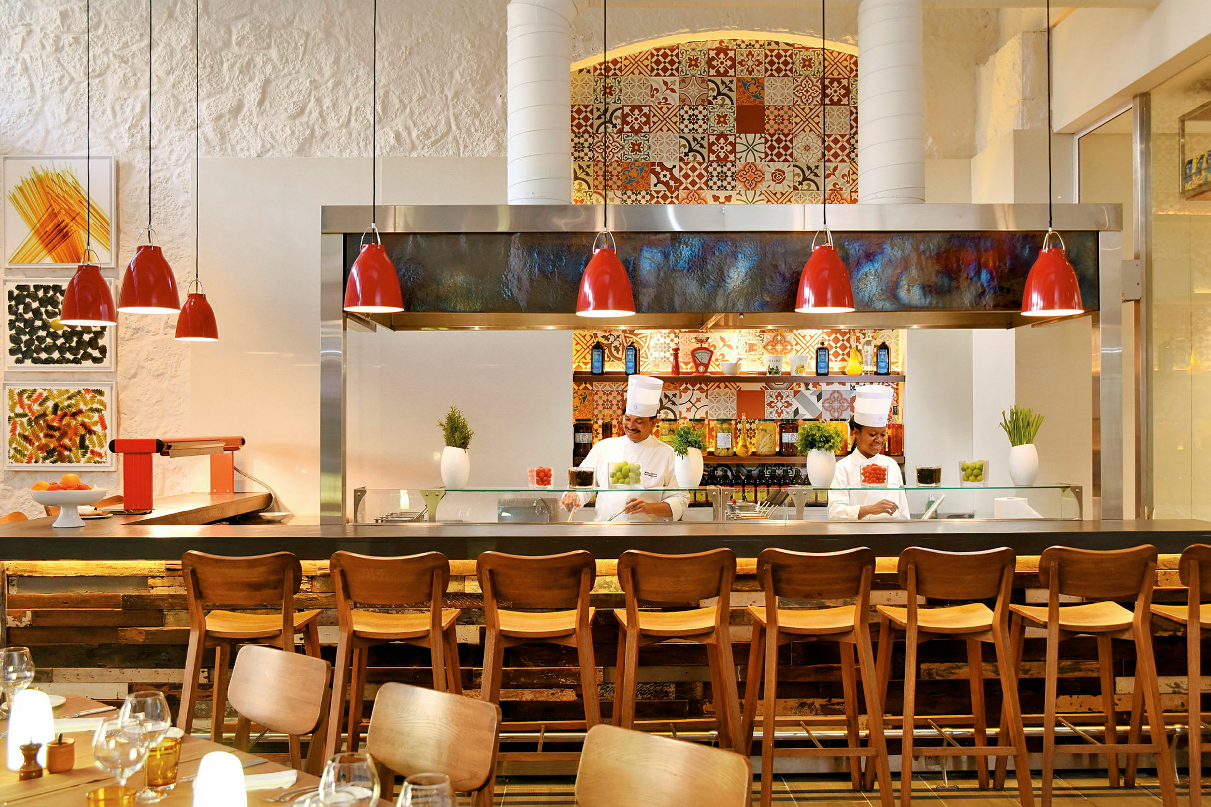 Interiør av en restaurant med trestoler, moderne kjøkken med røde lamper og dekorert bakgrunn. (AI-generert tekst)