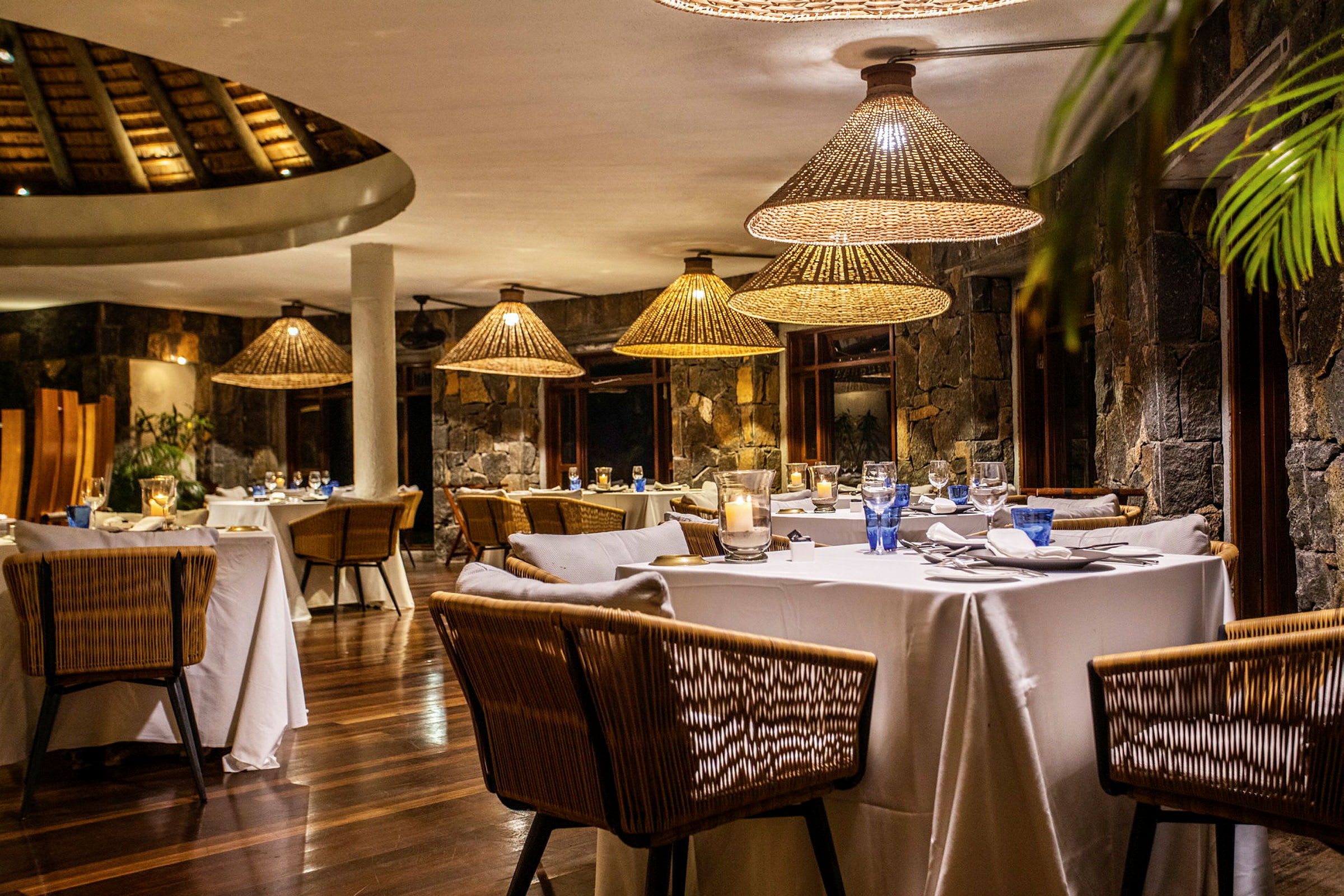 En elegant restaurant med dekkede bord og rottinglamper. (AI-generert tekst)