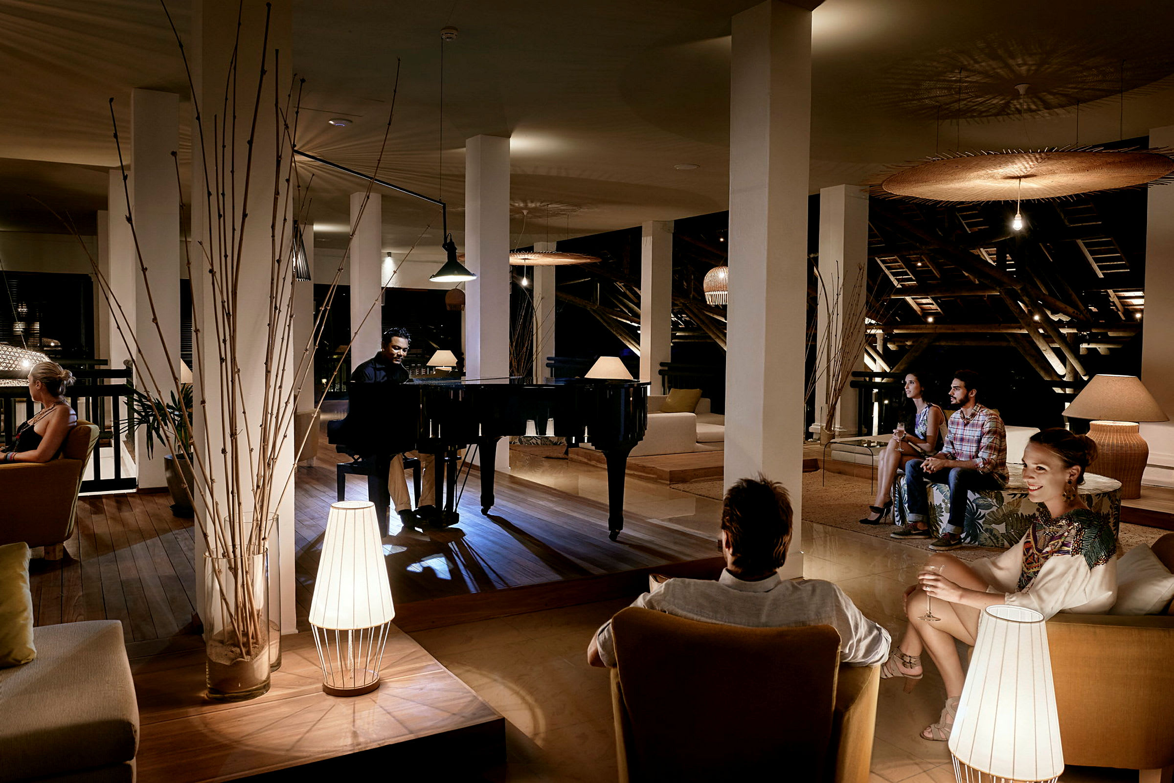 En elegant lounge med et flygel og sitteplasser i dempet belysning. (AI-generert tekst)