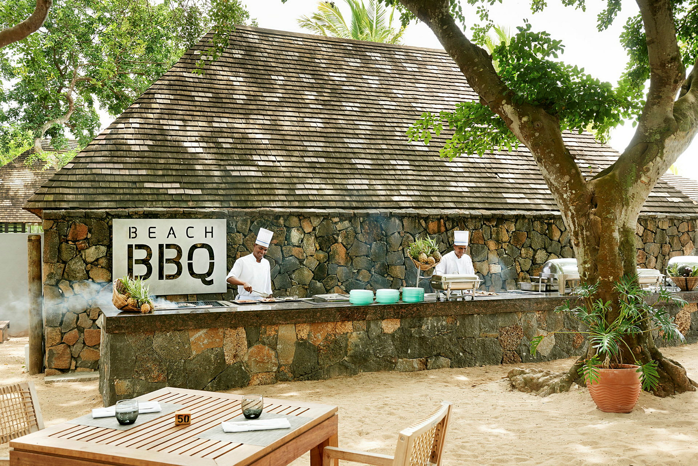 Bilde av en utendørs servering med steinbygning og BBQ-område. (AI-generert tekst)