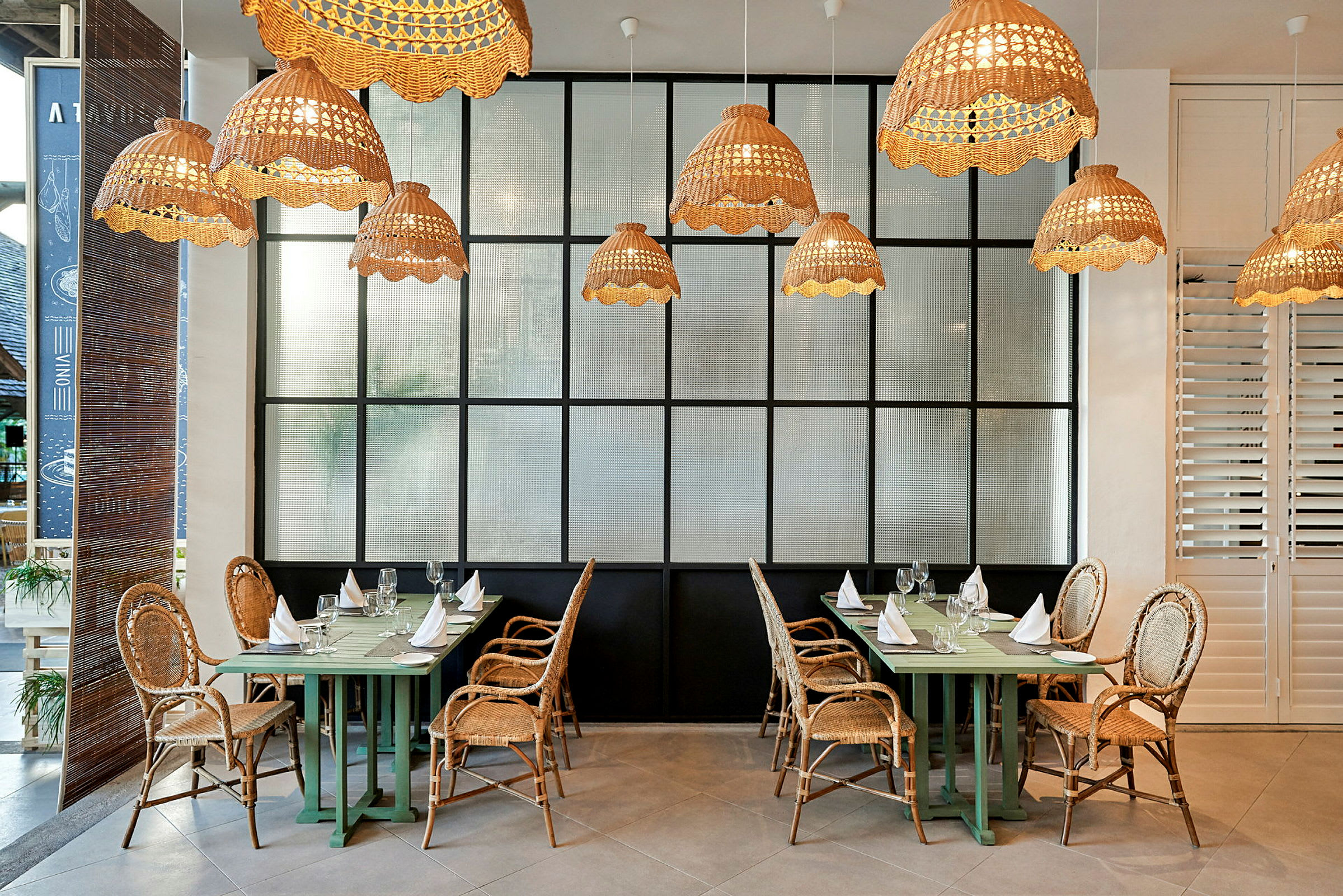 Restaurant med rottingstoler og hengende lamper. (AI-generert tekst)