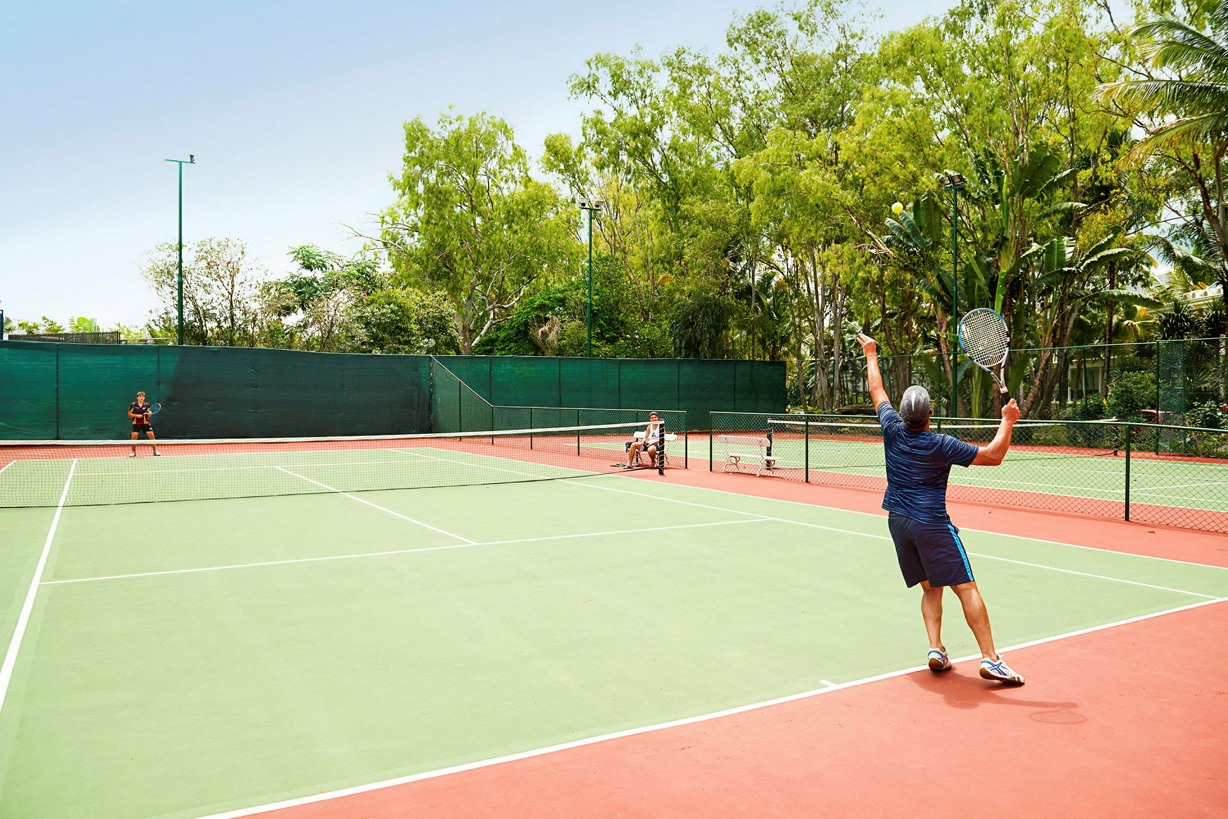 Personer spiller tennis på en utendørsbane. (AI-generert tekst)