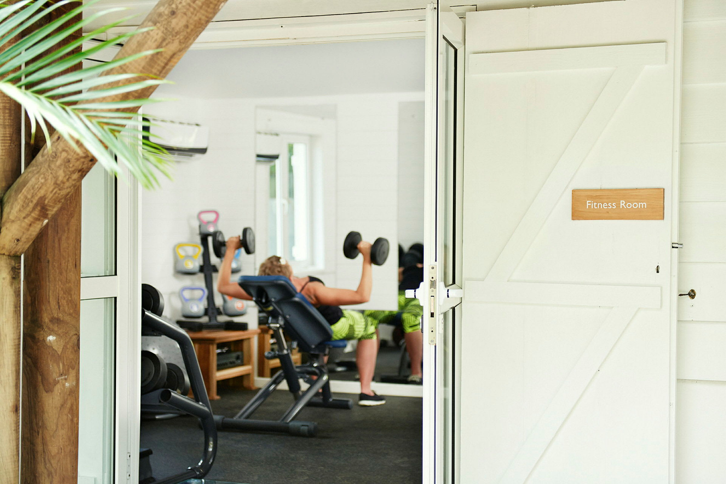 Gym med person som trener med hantler. (AI-generert tekst)