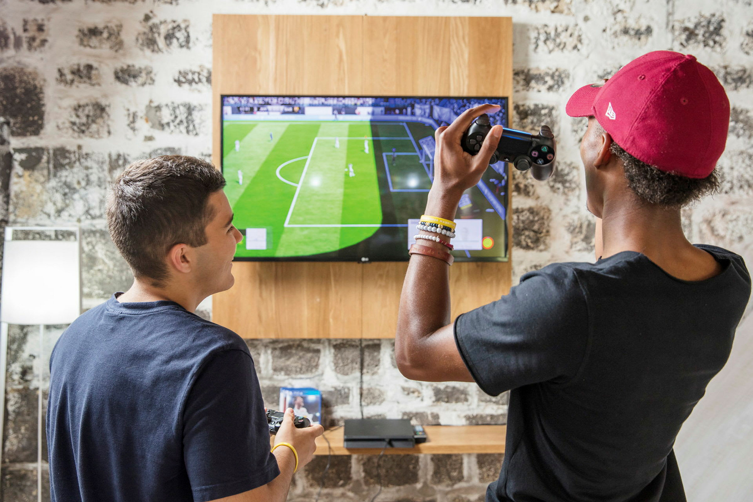 To personer spiller et fotballspill på en TV-skjerm. (AI-generert tekst)