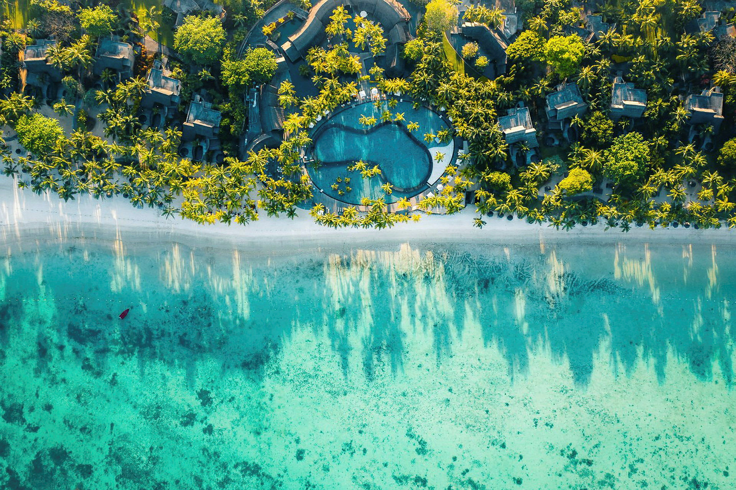 Flyfoto av tropisk resort med basseng og strand. (AI-generert tekst)