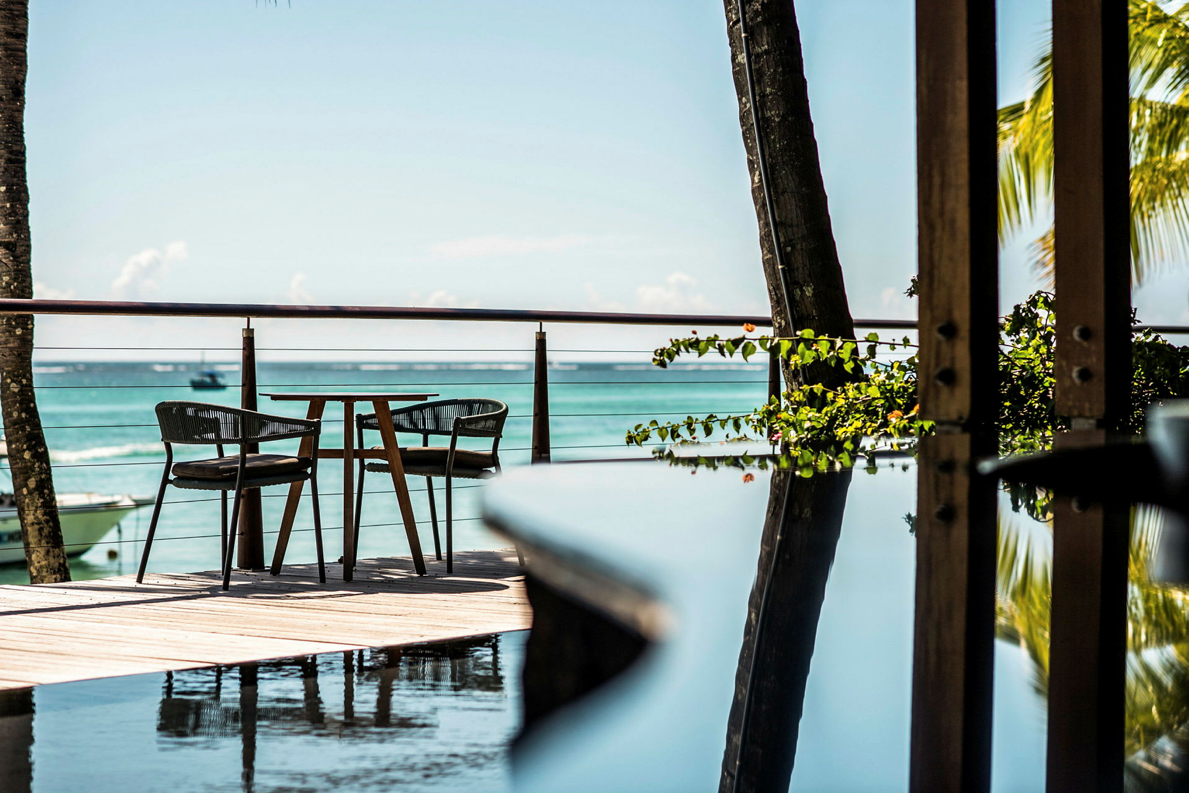 To stoler og et bord på en terrasse med utsikt over havet. (AI-generert tekst)