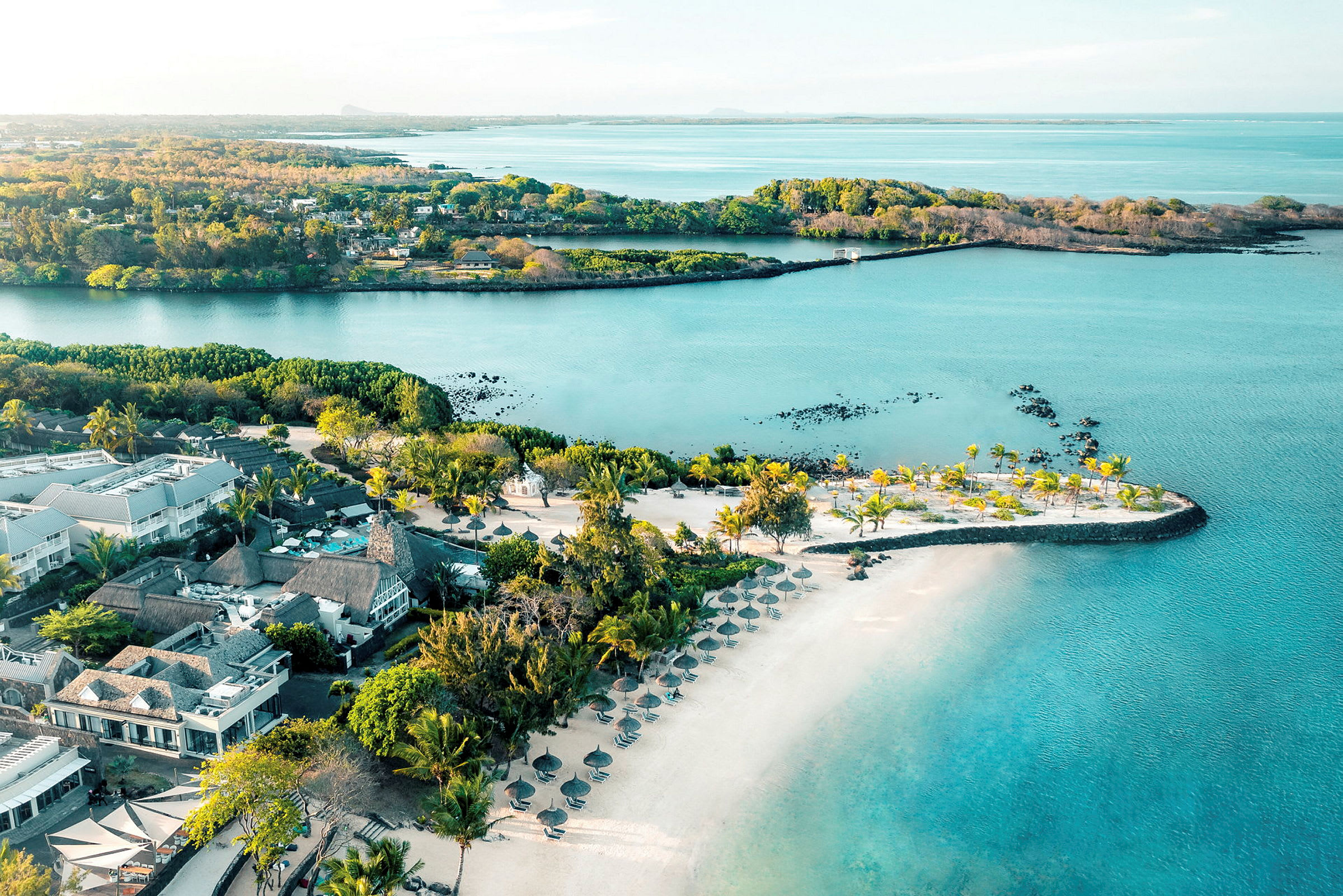 Luftutsikt over resort ved vannet med palmer og strand. (AI-generert tekst)
