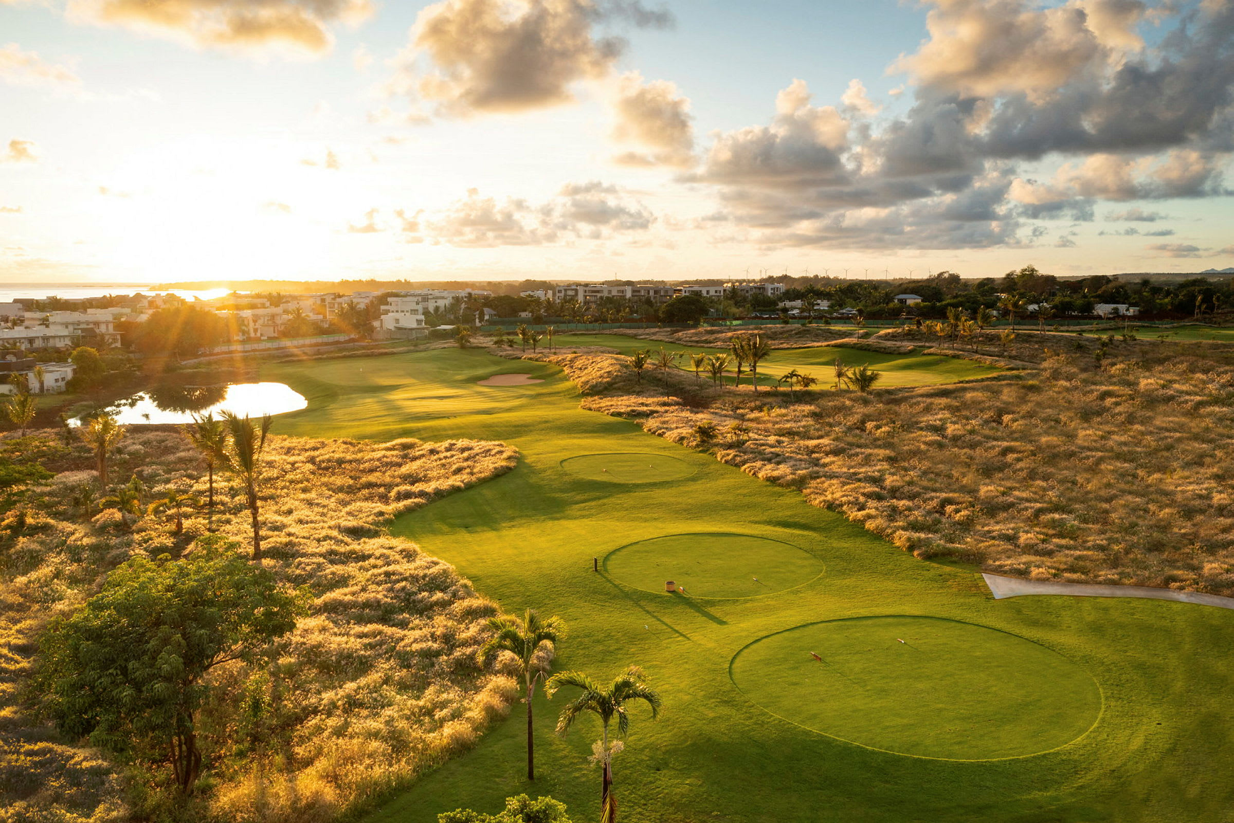 Utsikt over en golfbane i solnedgang med omkringliggende landskap. (AI-generert tekst)