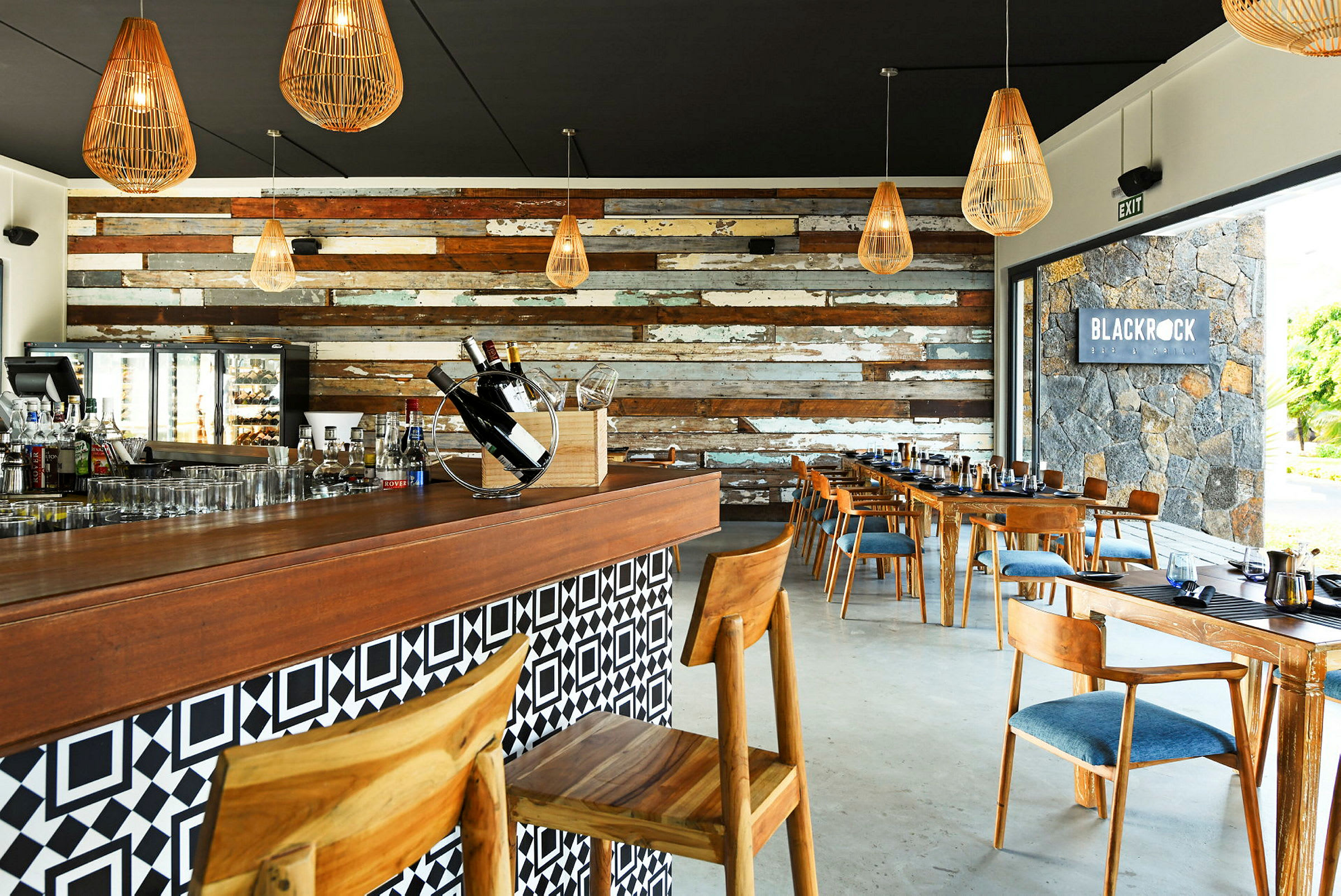 Interiør av en restaurant med trematerialer og dekorative lamper. Baren har stoler og bord med tredetaljer. (AI-generert tekst)
