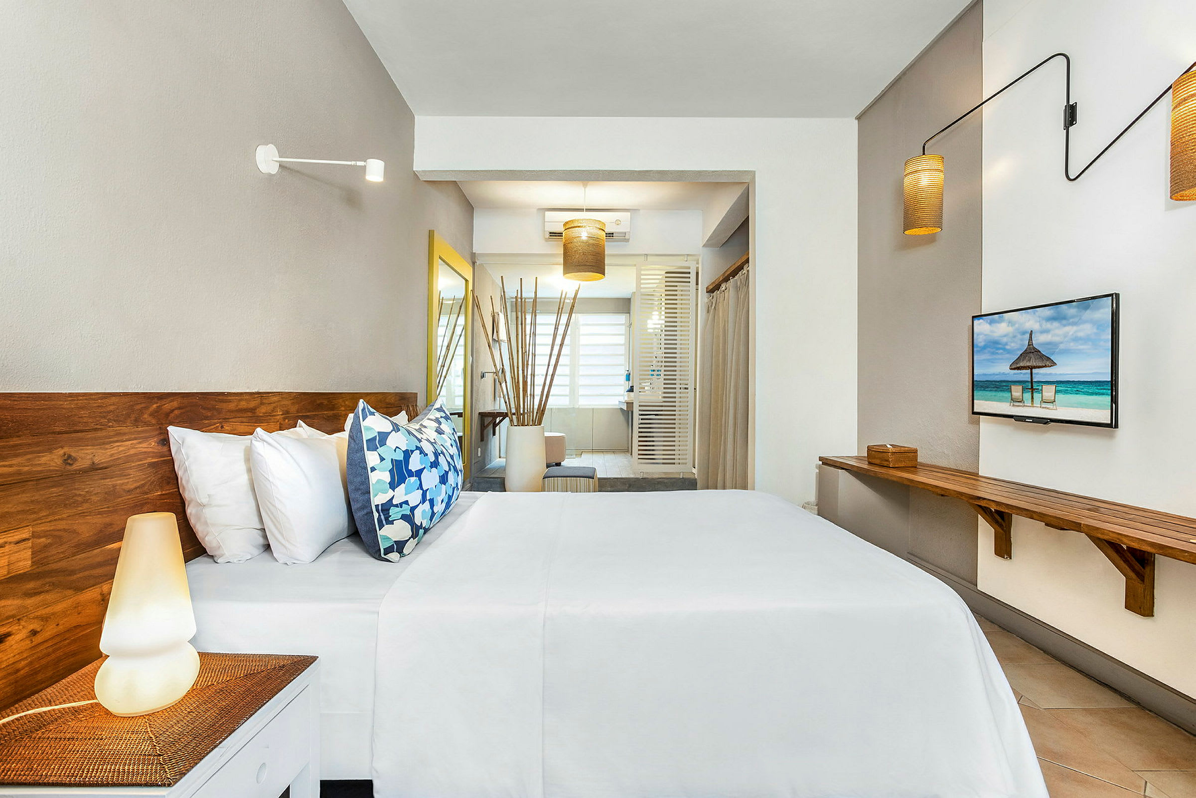 Bilde av et moderne hotellrom med tremøbler, seng med hvite laken og fargerike puter, og et stort vindu i bakgrunnen. (AI-generert tekst)