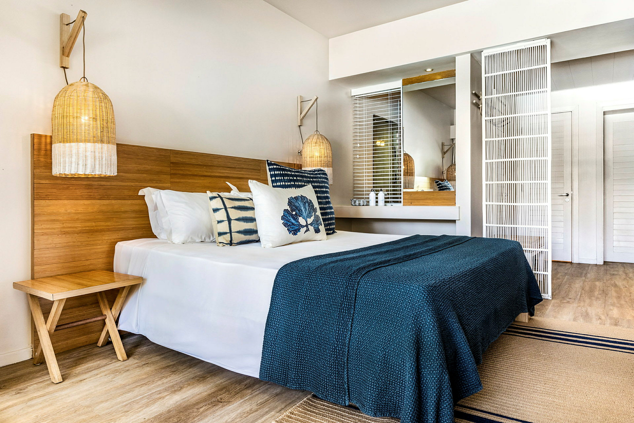 Et hotellrom med en dobbeltseng, tredetaljer og blå innredning. (AI-generert tekst)