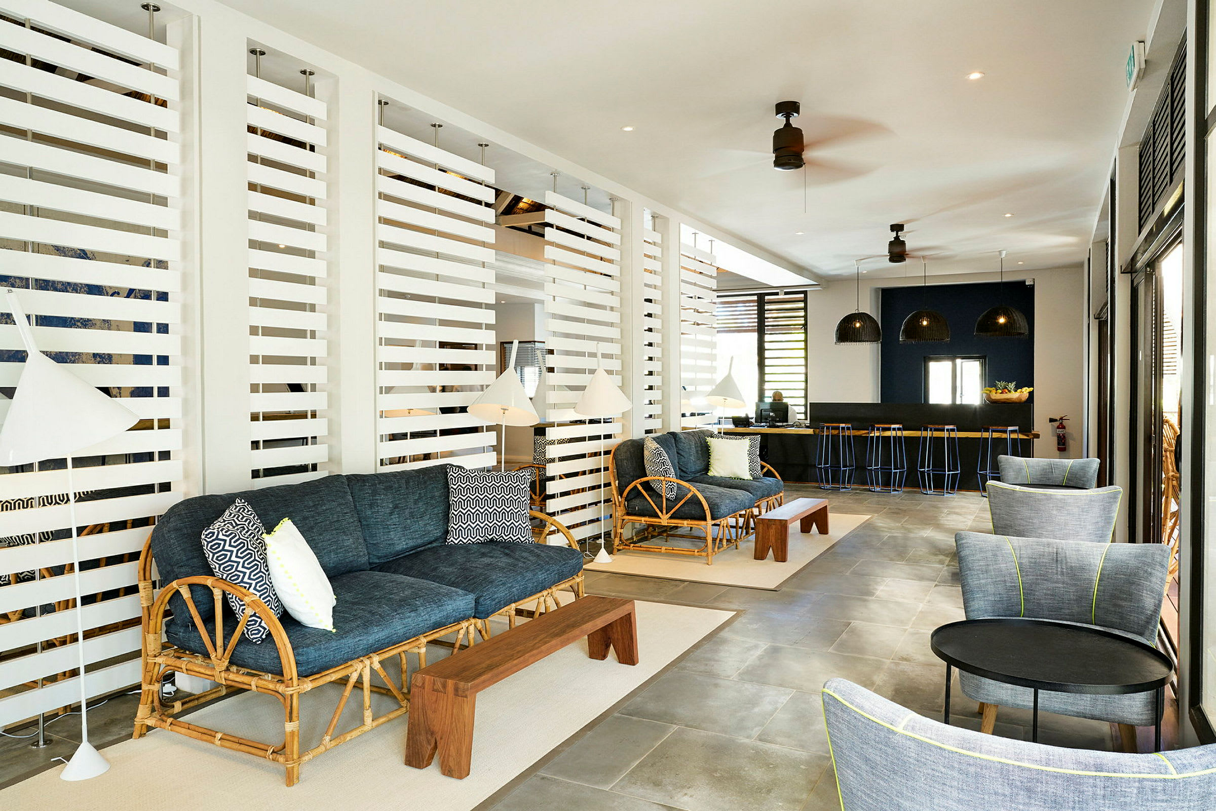 Et loungeområde med sofaer, belysning og en bar i bakgrunnen. (AI-generert tekst)